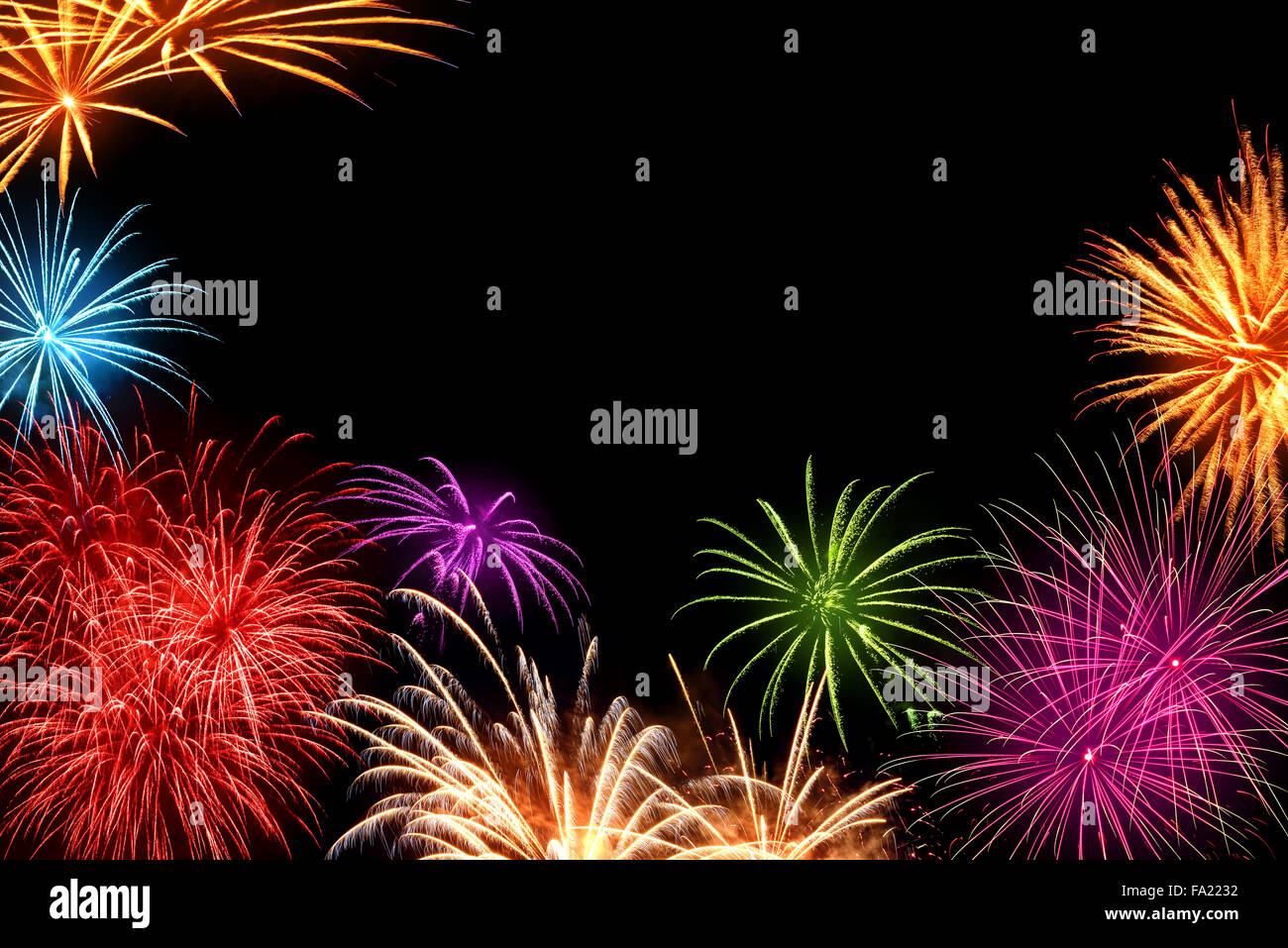 Gioiosa multi-colore di fuochi d'artificio come un telaio con copyspace nero in background, ideale per il Nuovo Anno o altri eventi celebrativi Foto Stock