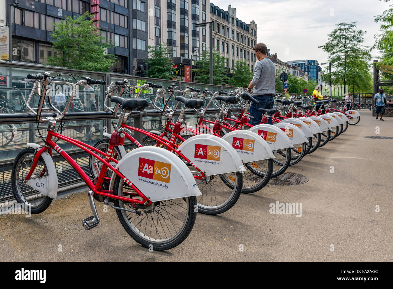 Anversa, Belgio - 11 ago: l uomo è il parcheggio di una bicicletta a un sistema automatico di noleggio biciclette per le biciclette condivise Foto Stock