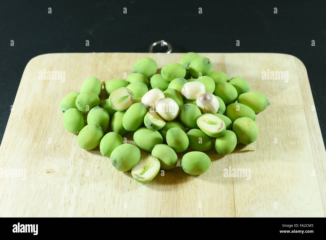 Semi di loto sul blocco di legno su sfondo nero Foto Stock