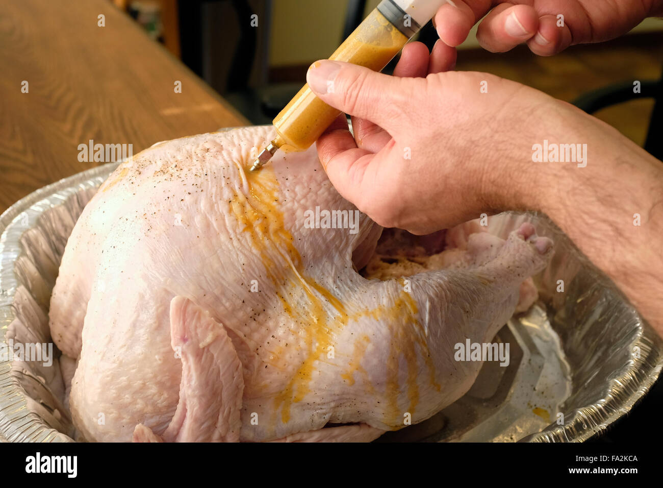 Utilizzando una siringa per iniettare una Turchia prima della cottura Foto Stock