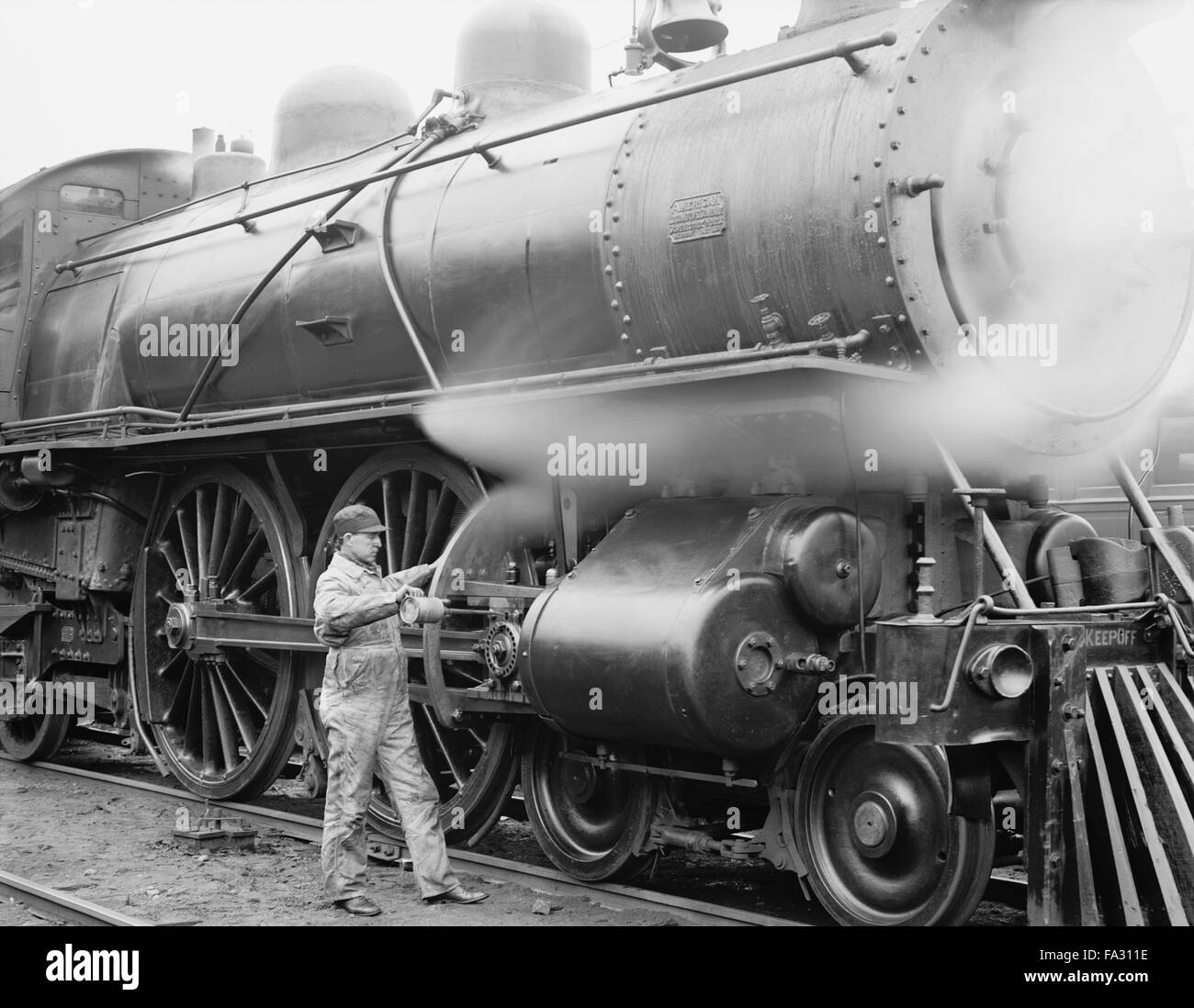 Meccanico di olio di lubrificazione ingranaggi sul treno, USA, 1904 Foto Stock