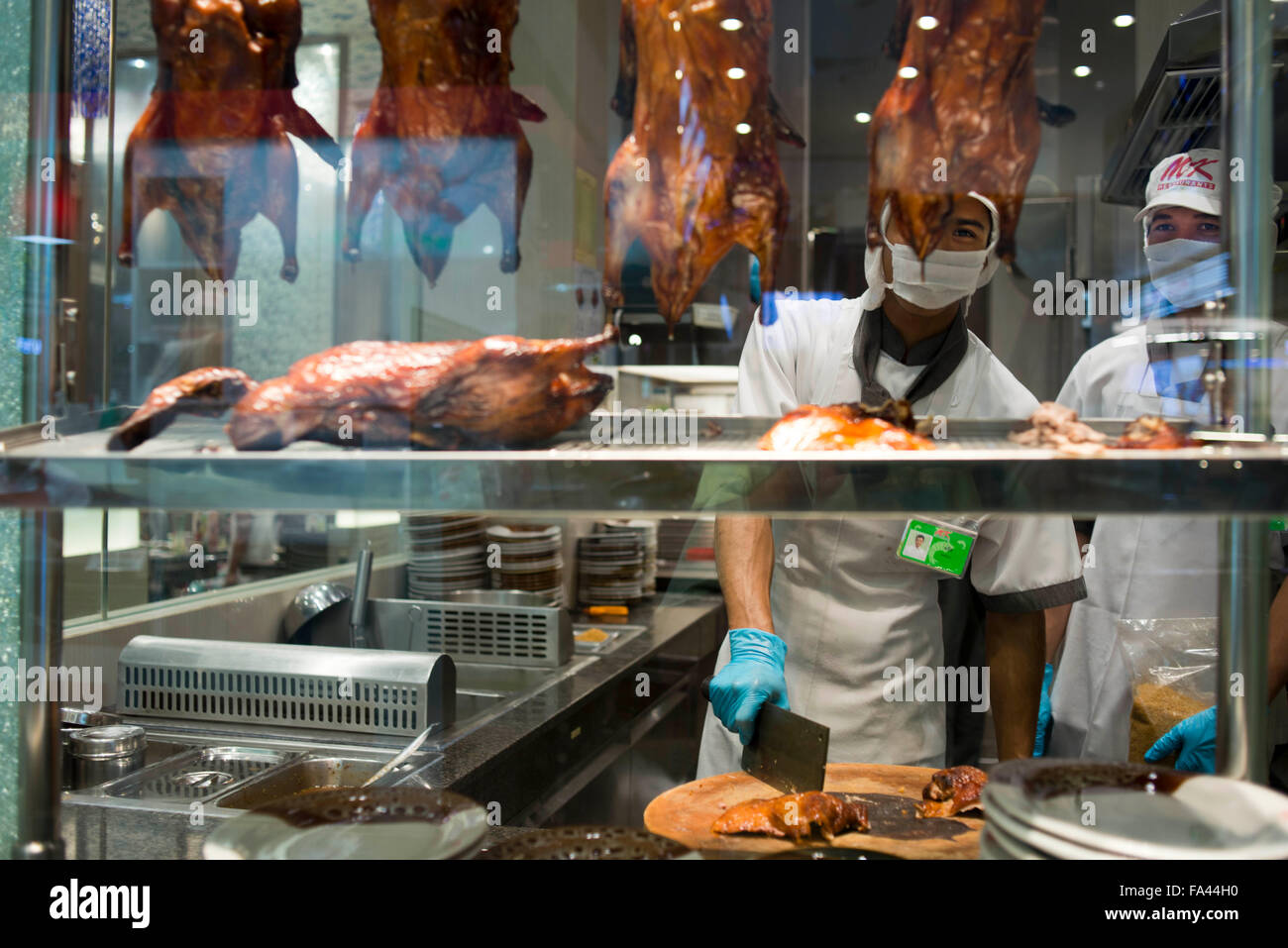 Cooker e torrefatto al tramonto in un restuarnt. Bangkok Chinatown mercato, Thailandia. Thanon Yaowarat road a notte nel centro di Chinatown d Foto Stock