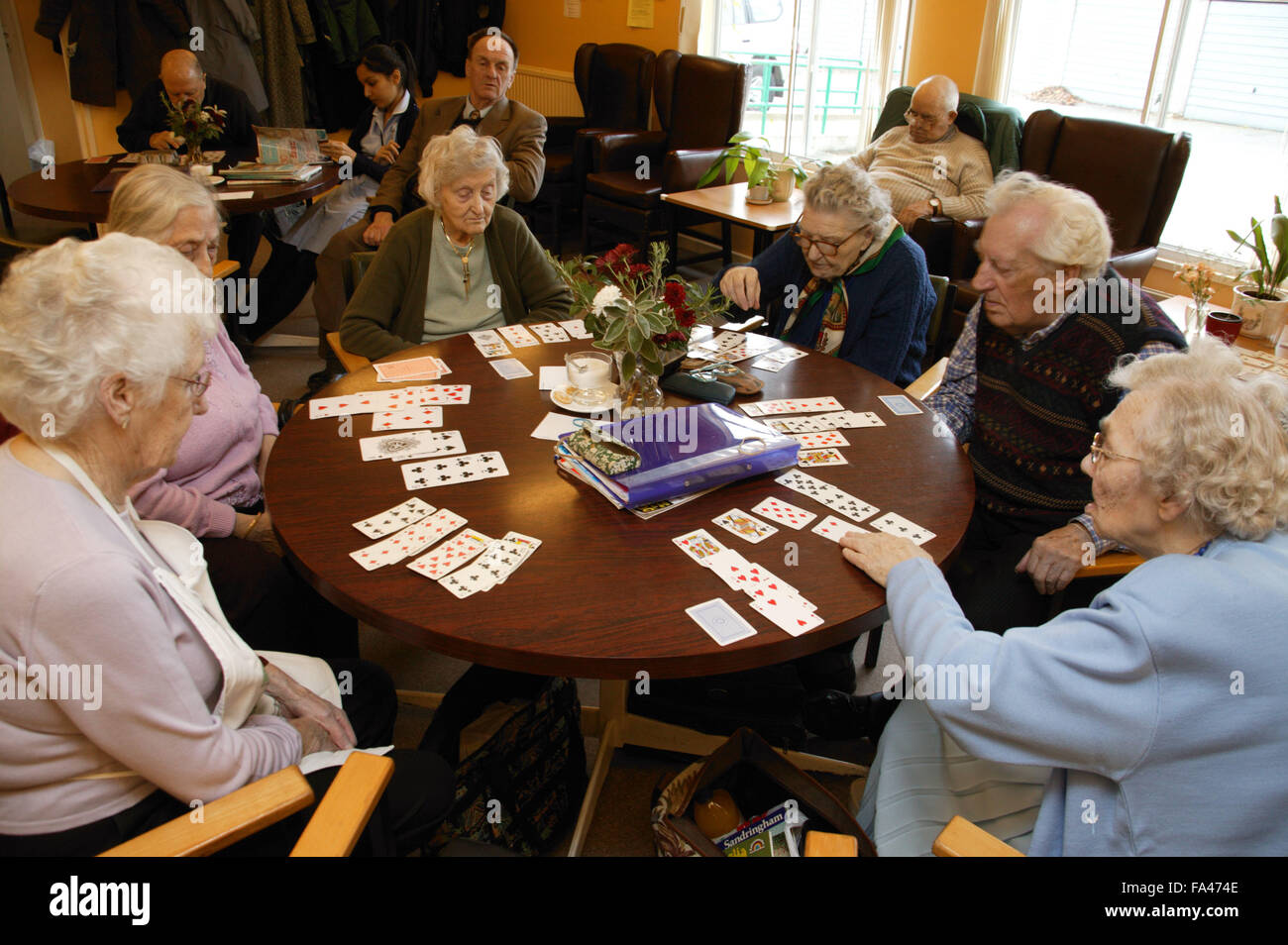 Gruppo di persone anziane godendo di un gioco di carte in un giorno centro, Foto Stock
