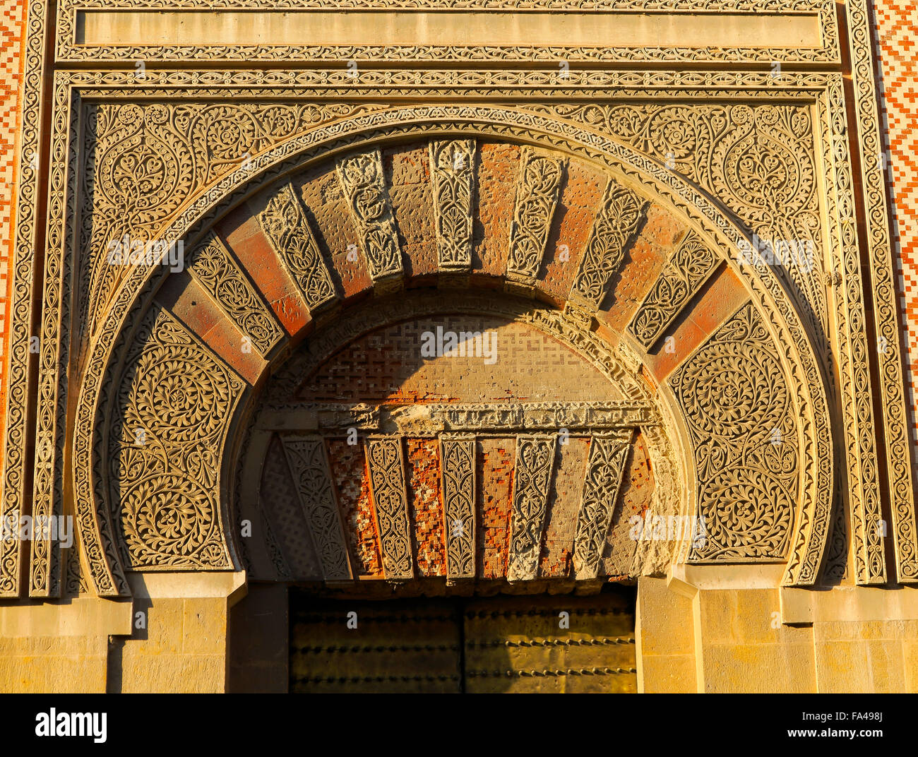 Moresco arco porta inscritto elaboratamente con muratura in pietra della Mezquita Moschea grande, Cordoba, Spagna Foto Stock