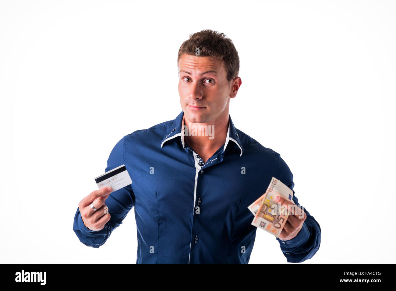 Giovane Azienda banconote e carte di credito, scegliendo tra i due mezzi di pagamento. Isolato, studio shot Foto Stock