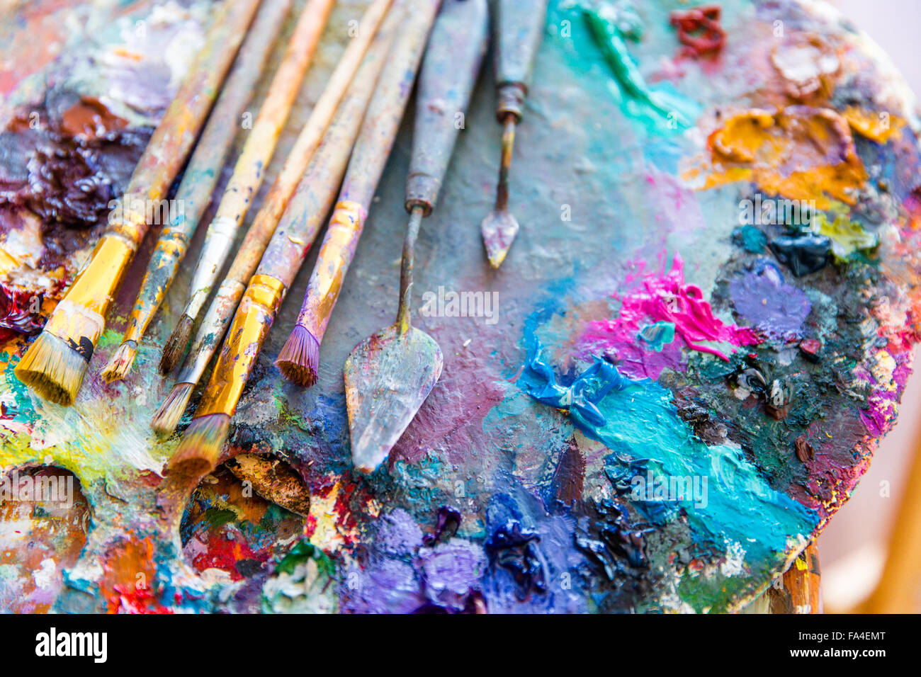 Immagine di sfondo di luminosi colori misti vernici su arte tavolozza con pennelli  e spatole Foto stock - Alamy
