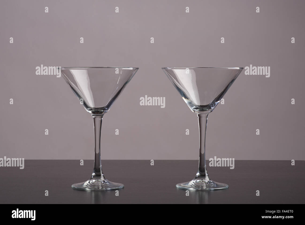 Due bicchieri da Martini in piedi sul tavolo scuro Foto Stock