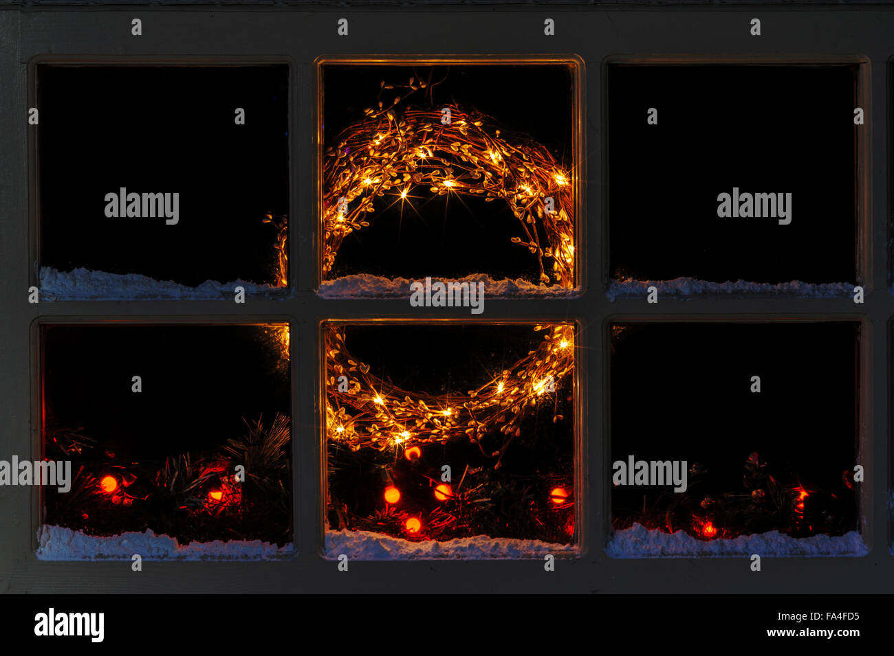Ghirlanda illuminato e albero di Natale luci attraverso una finestra lodge. Foto Stock