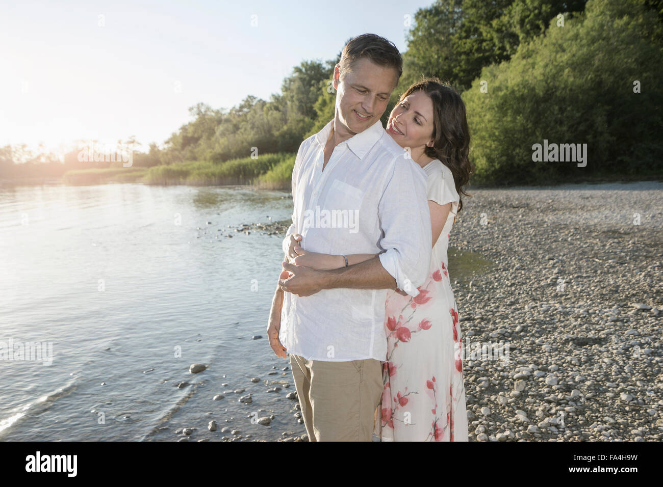 Coppia matura romancing a Lakeside e sorridente, Baviera, Germania Foto Stock