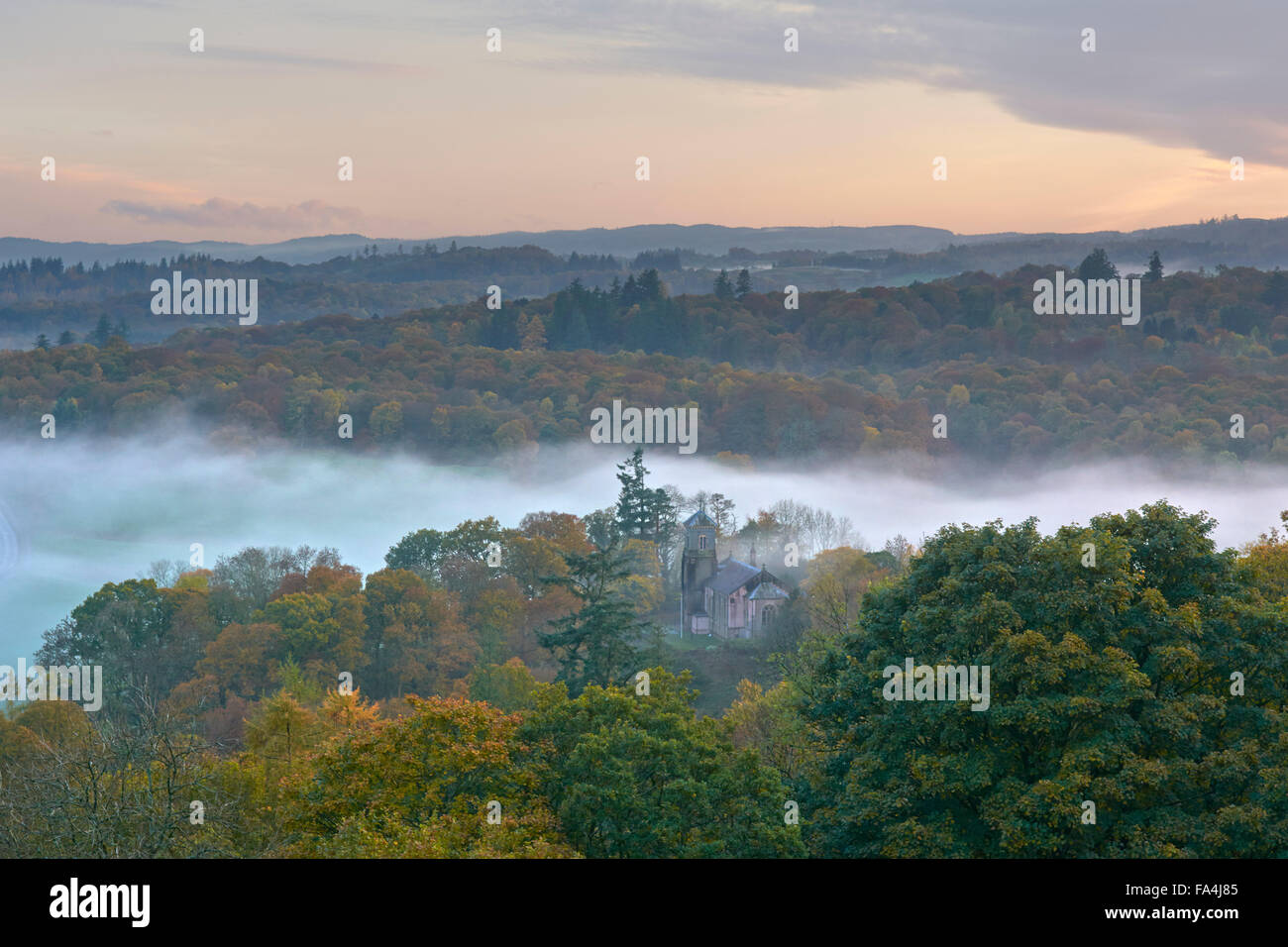 Chiesa della Santa Trinità a Brathay circondato da nebbia autunnale - Lake District, England, Regno Unito Foto Stock