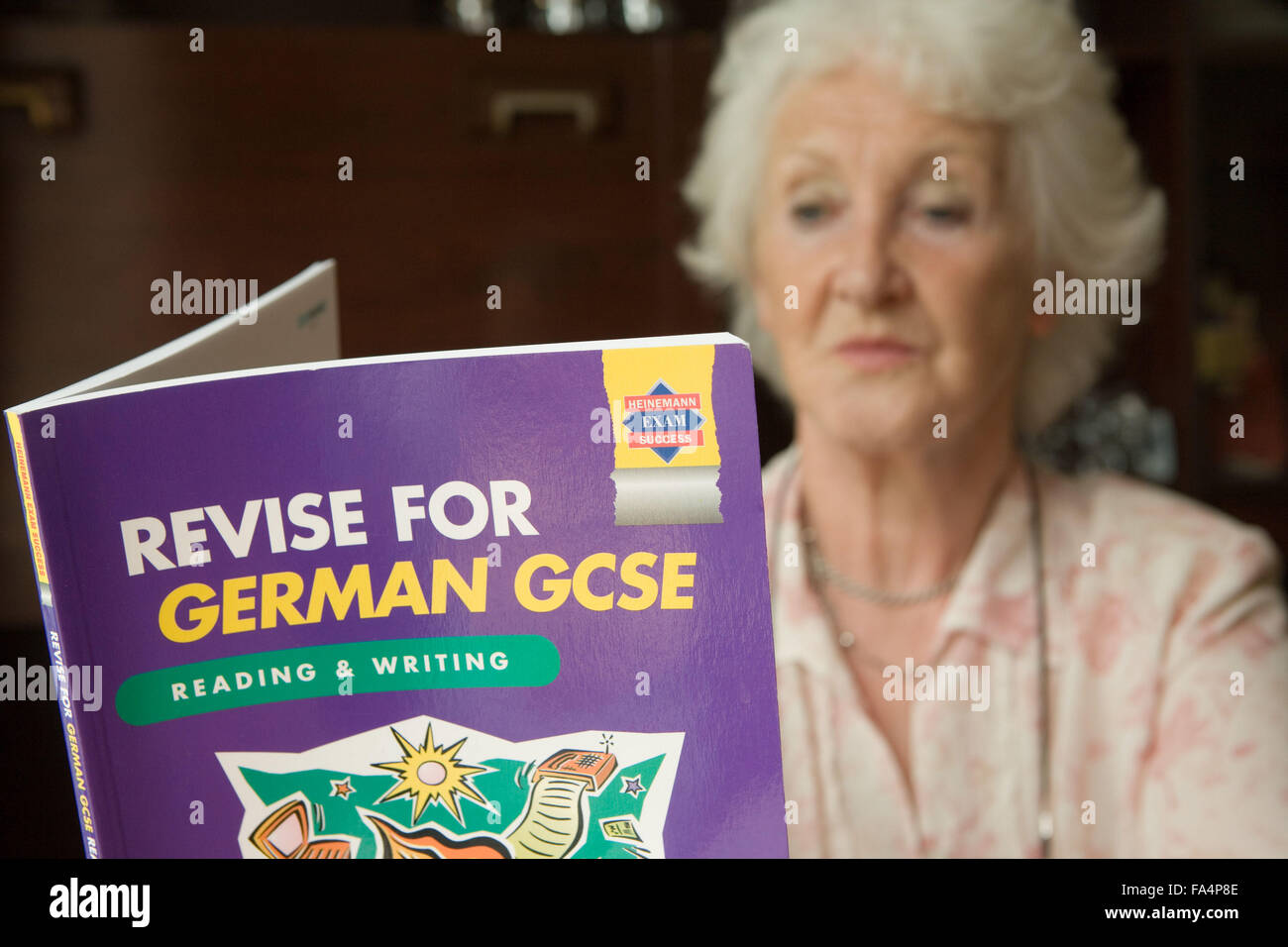 Donna anziana la revisione per il tedesco GCSE, Foto Stock
