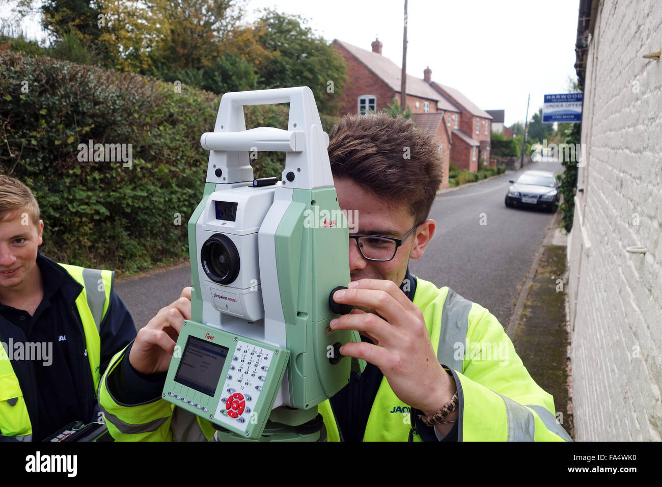 Geometra utilizzando Leica pinpoint R1000 Ottica attrezzature Sondaggio Regno Unito Foto Stock