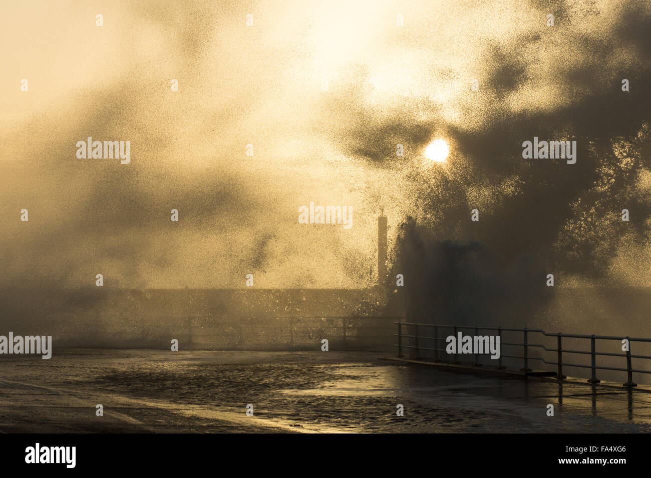 Aberystwyth, Wales, Regno Unito. Il 21 dicembre 2015. Regno Unito: Meteo in mezzo s GOLDEN SUNSET, onde infrangersi sulla parete del porto creando un Armageddon-come credito di immagine: Alan Hale/Alamy Live News Foto Stock