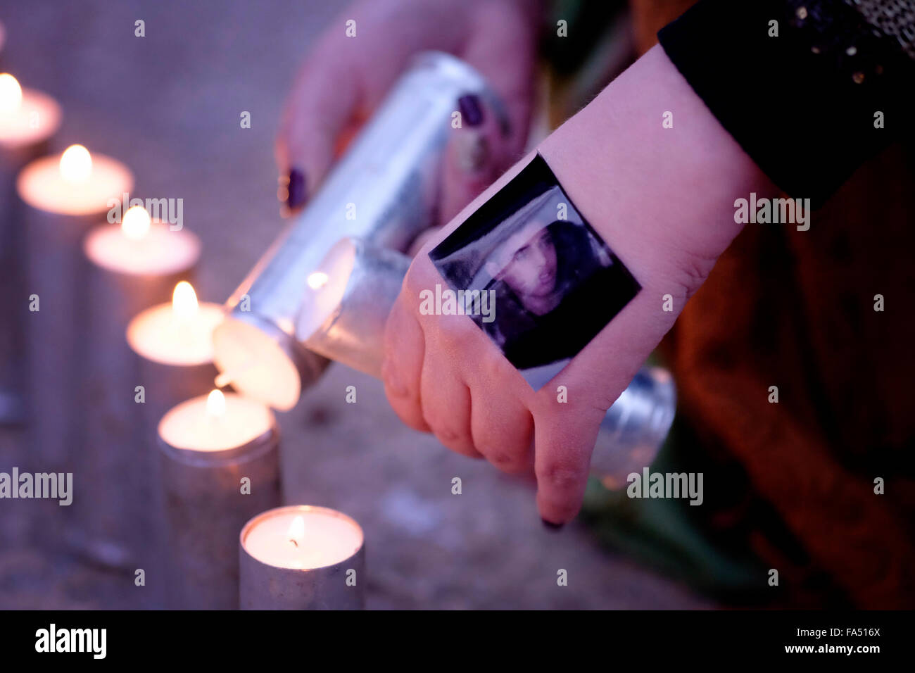 Una donna palestinese accende candele commemorative in bombole di gas lacrimogeni riutilizzate durante una veglia tenuta in memoria di coloro che sono morti durante gli scontri con i soldati israeliani in Cisgiordania Foto Stock