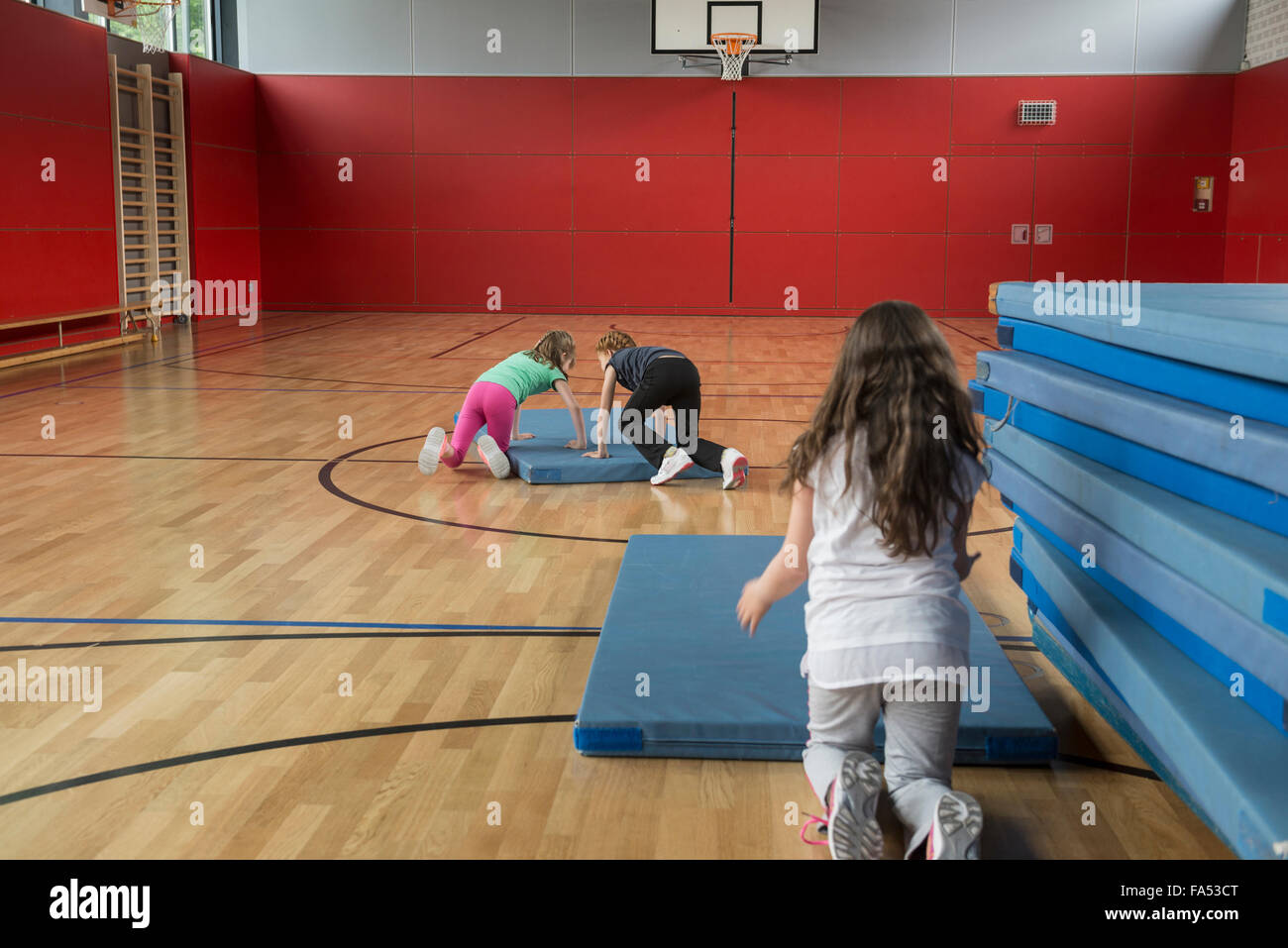 Ragazze disponendo i tappetini di sport nella pallacanestro, Monaco di Baviera, Germania Foto Stock