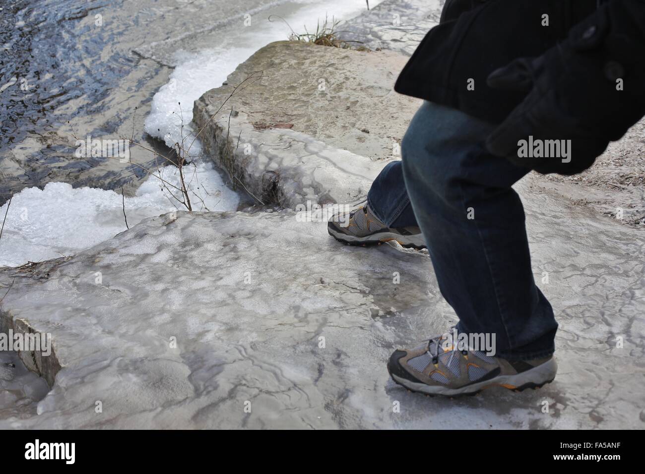 Un uomo lo scivolamento su un gelido rock. Foto Stock