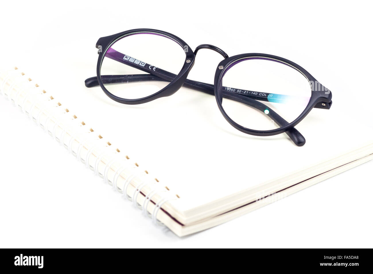 Vuoto notebook a spirale e occhiali isolati su sfondo bianco, stock photo Foto Stock