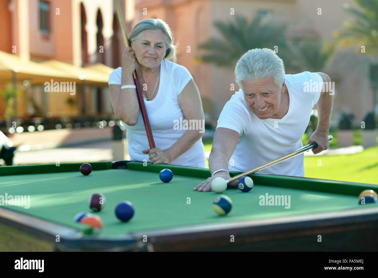 Vecchia coppia in vacanza giocando a biliardo Foto Stock