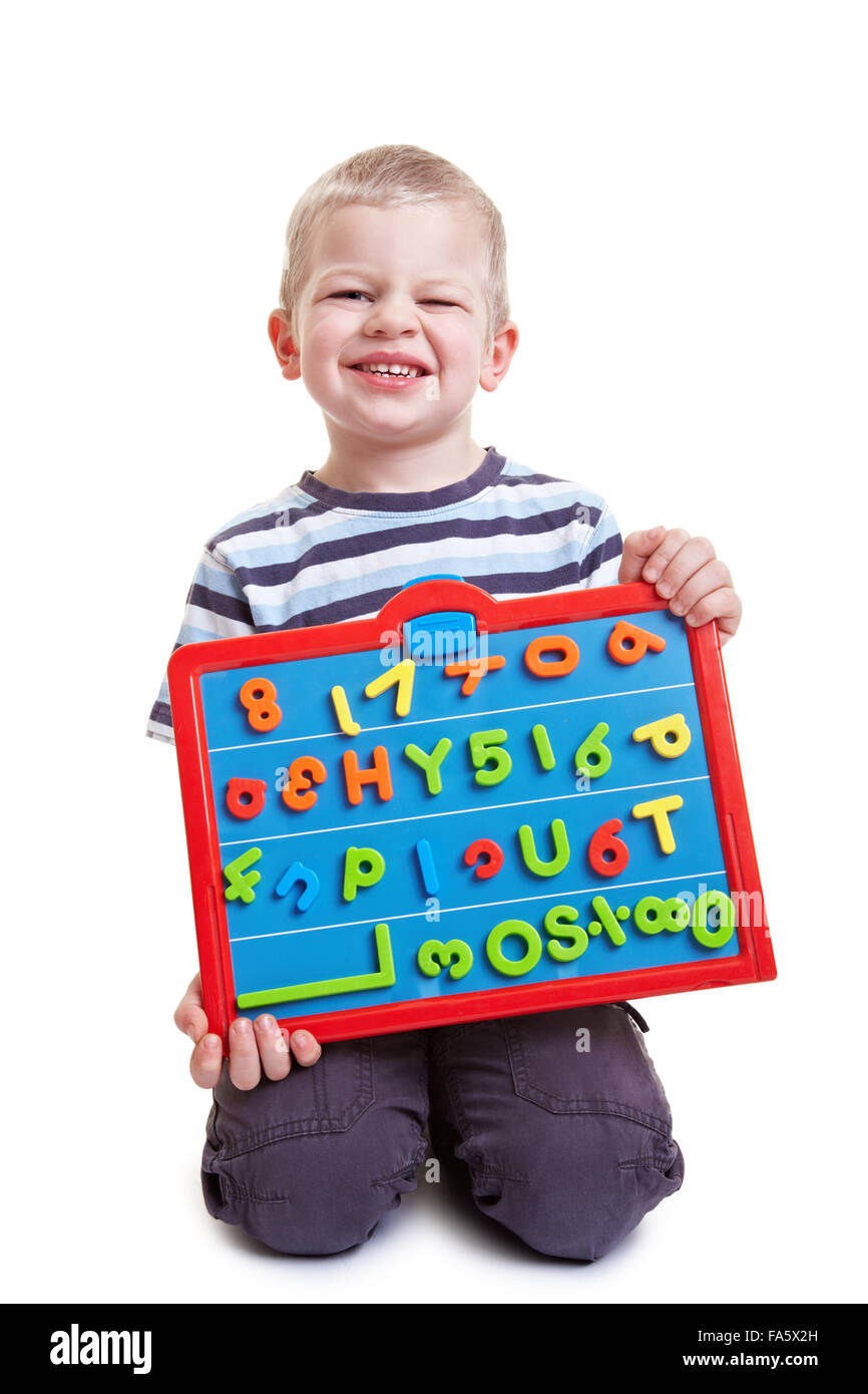 Happy little boy tenendo una scheda magnetica con lettere e numeri Foto Stock