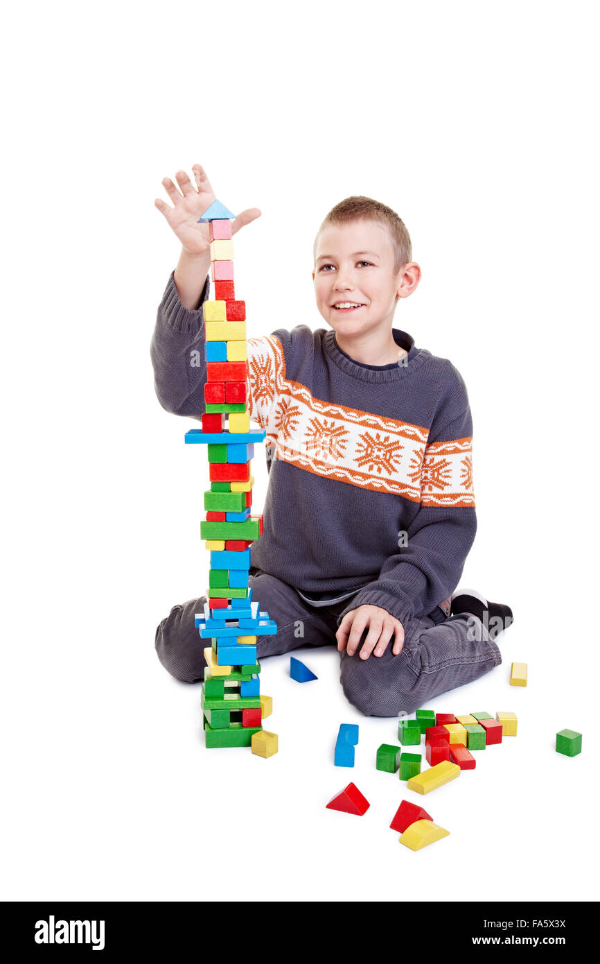 Ragazzo con cautela la costruzione di una torre con mattoni da costruzione Foto Stock