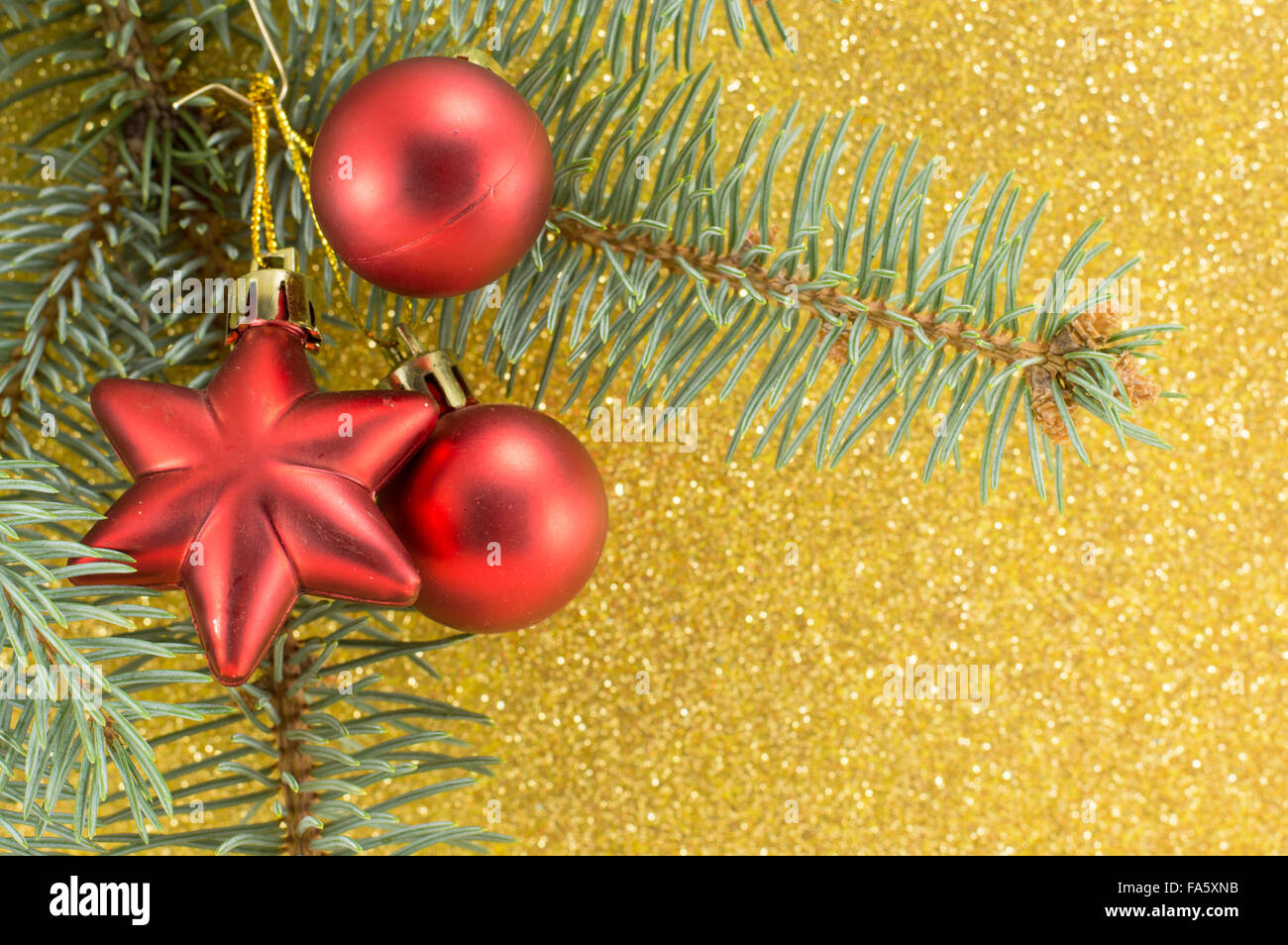 Rosso Natale ornamenti e abete del ramo su sfondo giallo Foto Stock