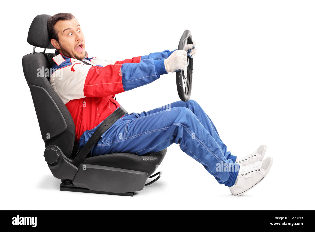 Studio shot di una giovane car racer fingendo di guidare molto veloce seduto su un seggiolino per auto isolati su sfondo bianco Foto Stock