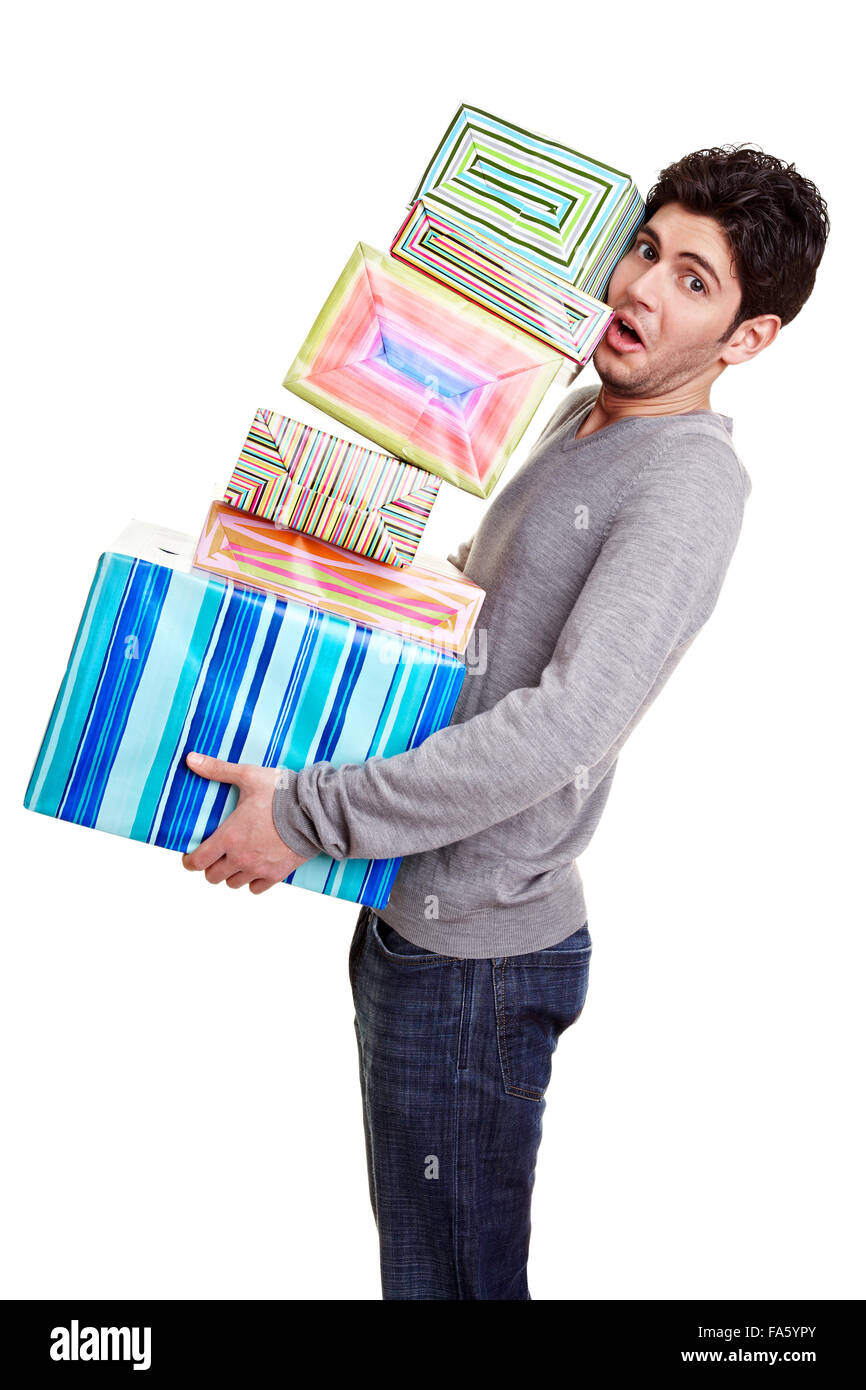 Uomo con cautela di bilanciamento di una pila di regali di natale Foto Stock