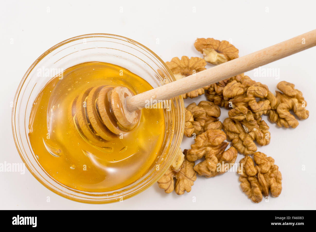 Le noci sbucciate e un vaso di miele su un tavolo Foto Stock