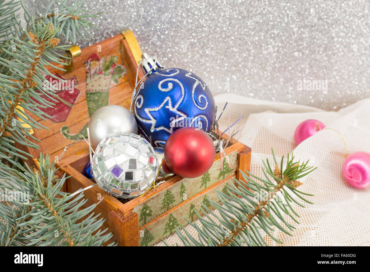 Colorate decorazioni di Natale in una scatola di legno e abete del ramo Foto Stock