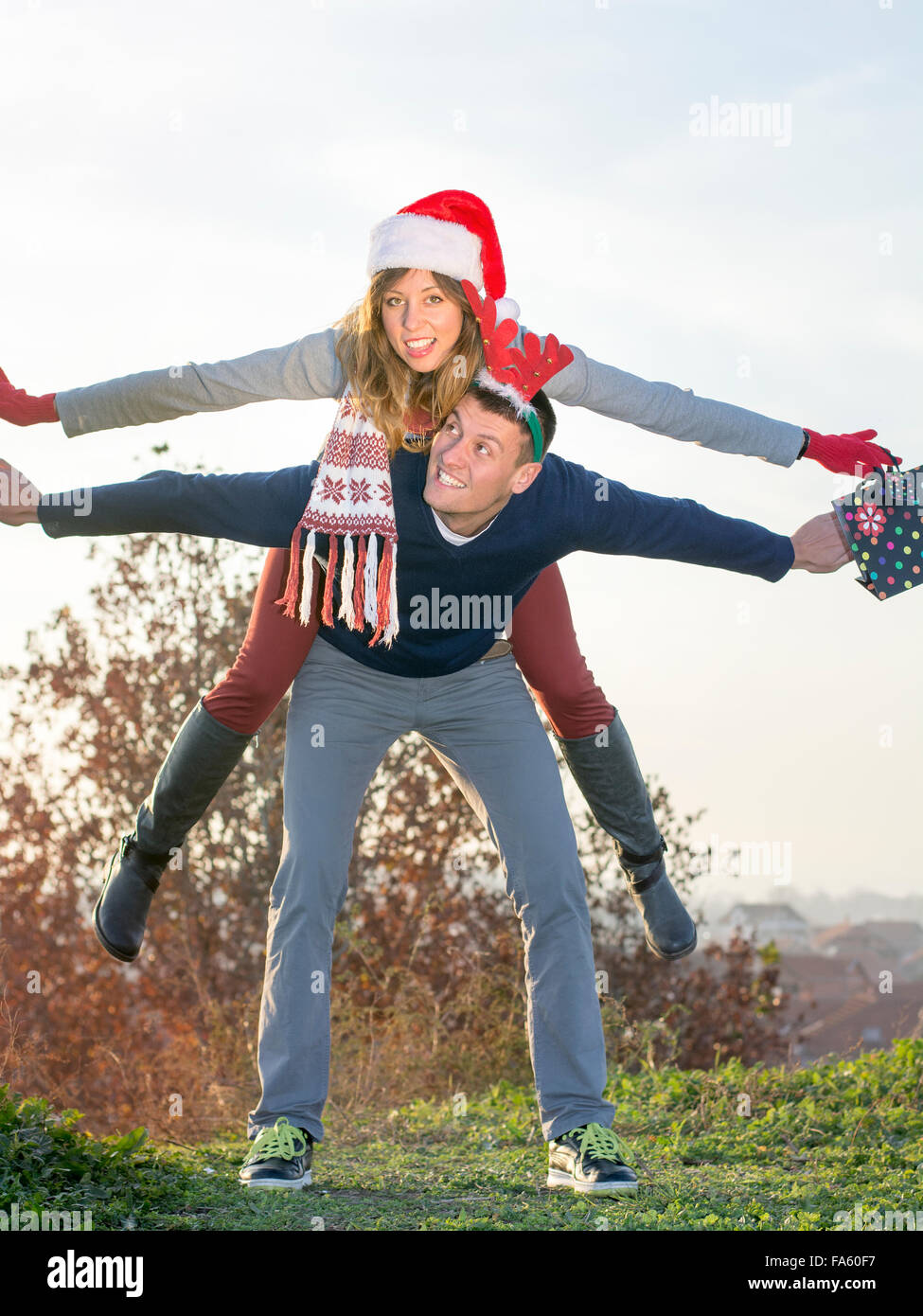 Giovane avendo divertimento all'aperto indossando vacanze di Natale cappelli Foto Stock