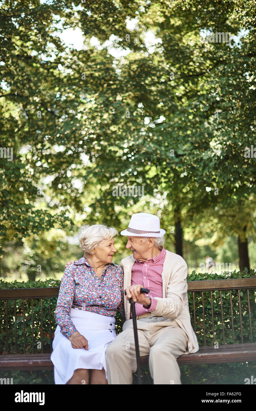 Happy seniors rilassante su banco in posizione di parcheggio Foto Stock