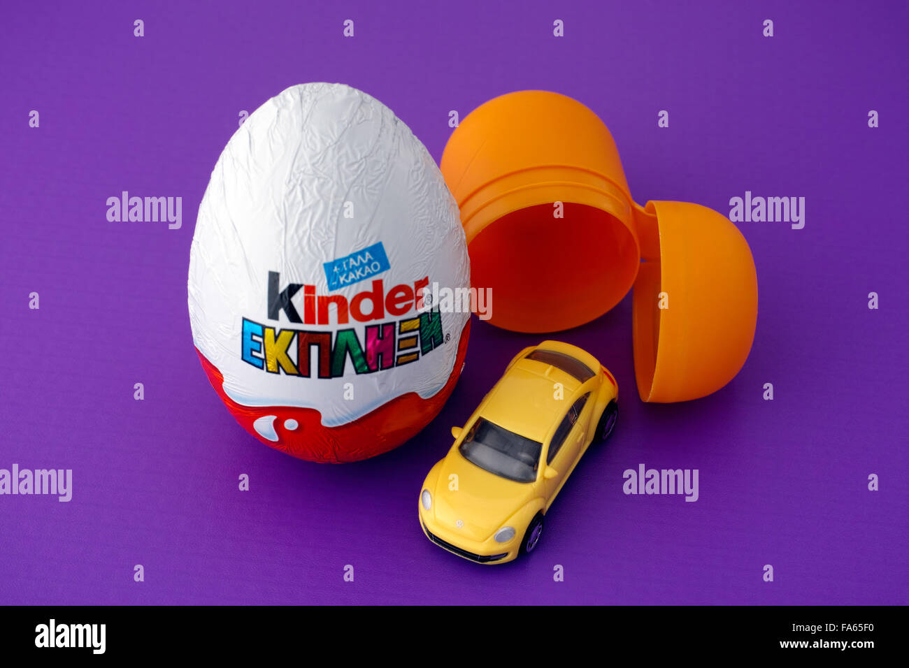 Paphos, Cipro - 27 novembre 2015 Kinder sorpresa uovo, la capsula di plastica e auto giocattolo sul sfondo viola. Foto Stock