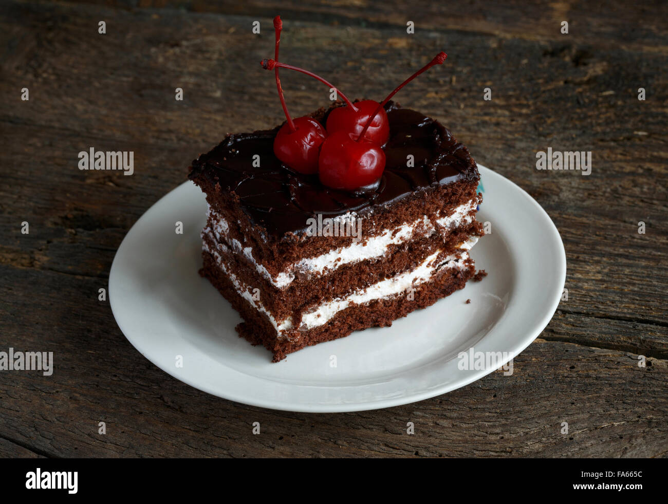 Squisite torte al cioccolato con cherry close-up su sfondo di legno Foto Stock