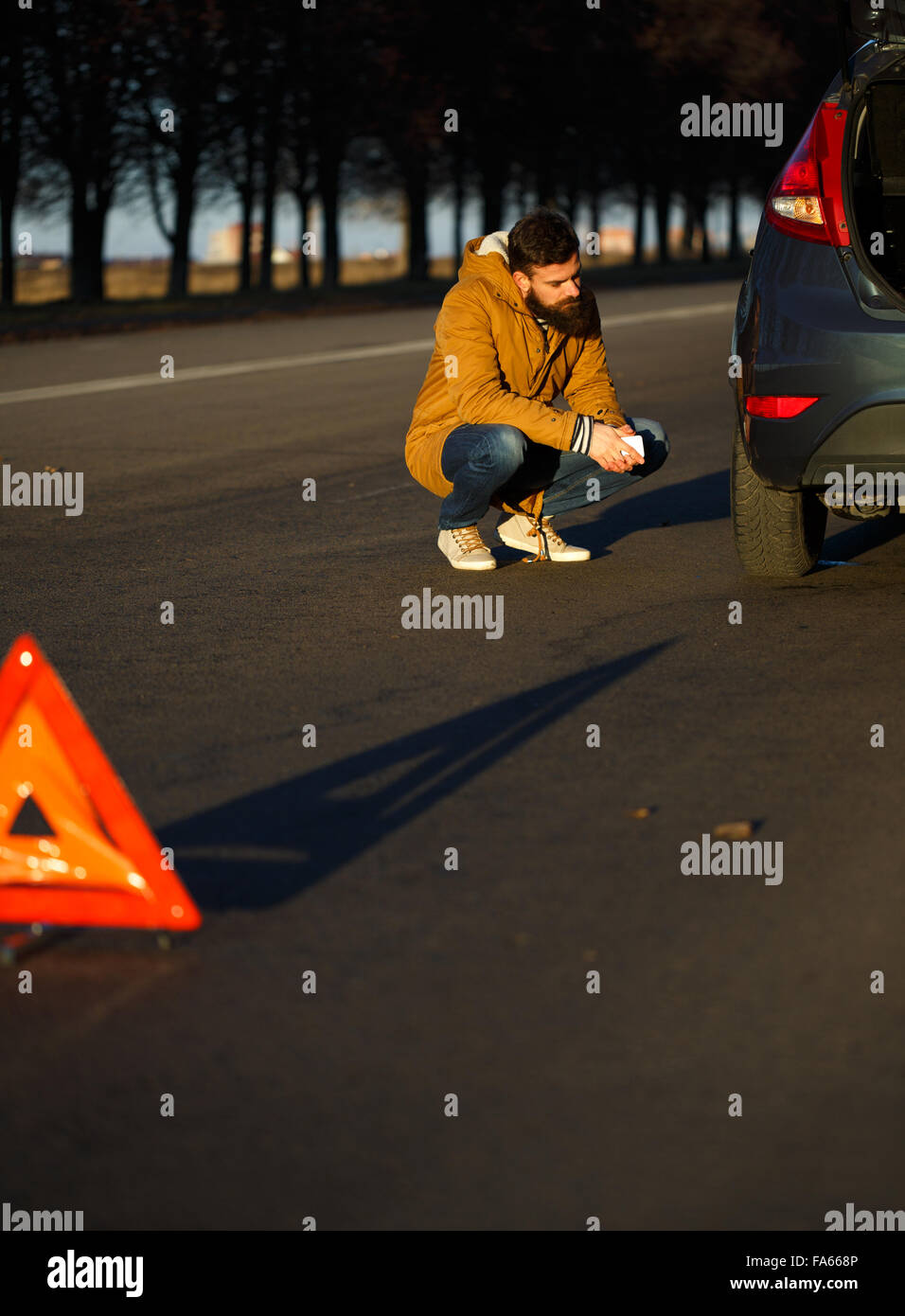 Autista uomo esaminando danneggiato automobili automobili dopo la rottura Foto Stock