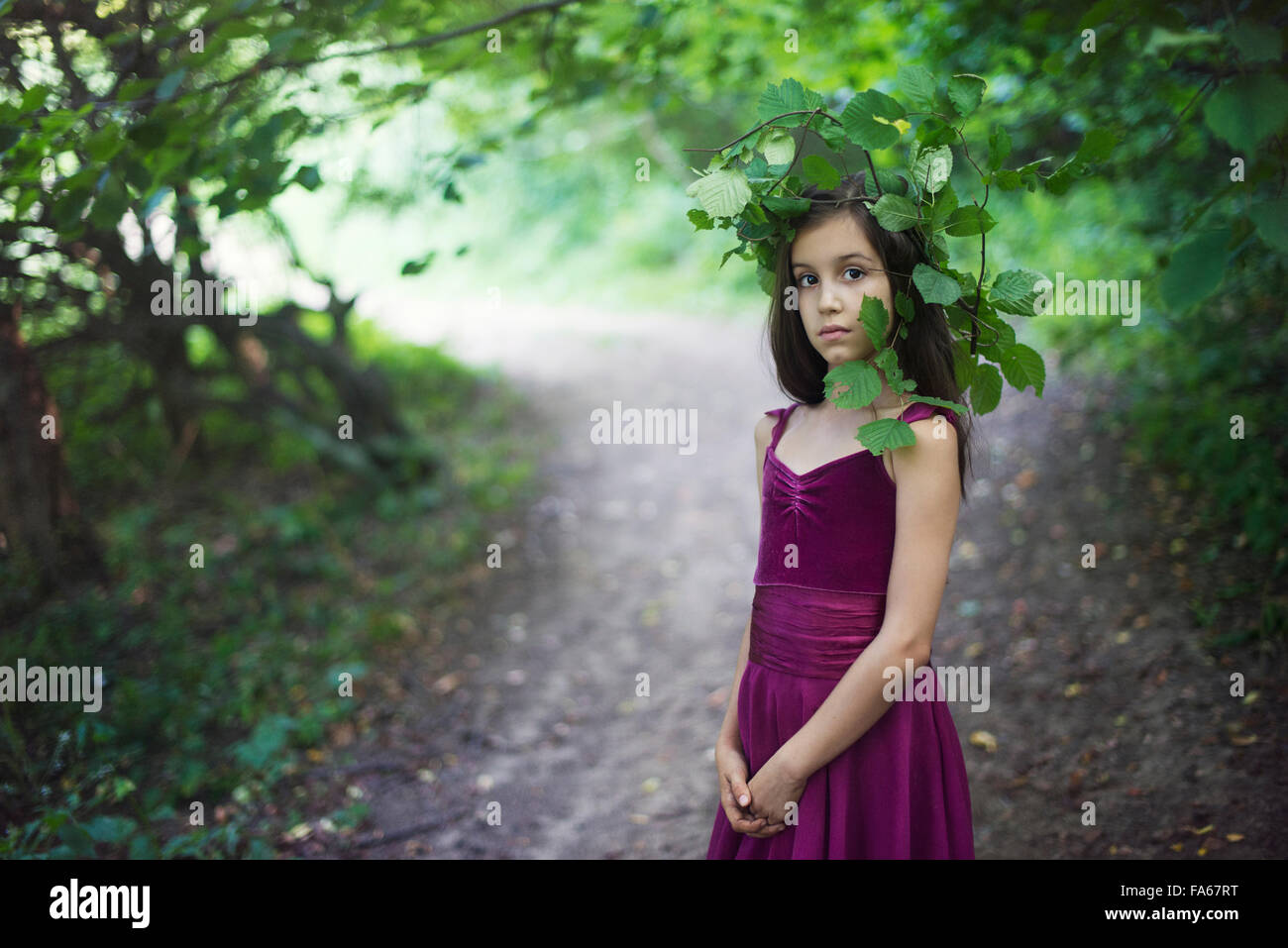 Ritratto di una ragazza in piedi in strada di indossare copricapo fatto di foglie Foto Stock