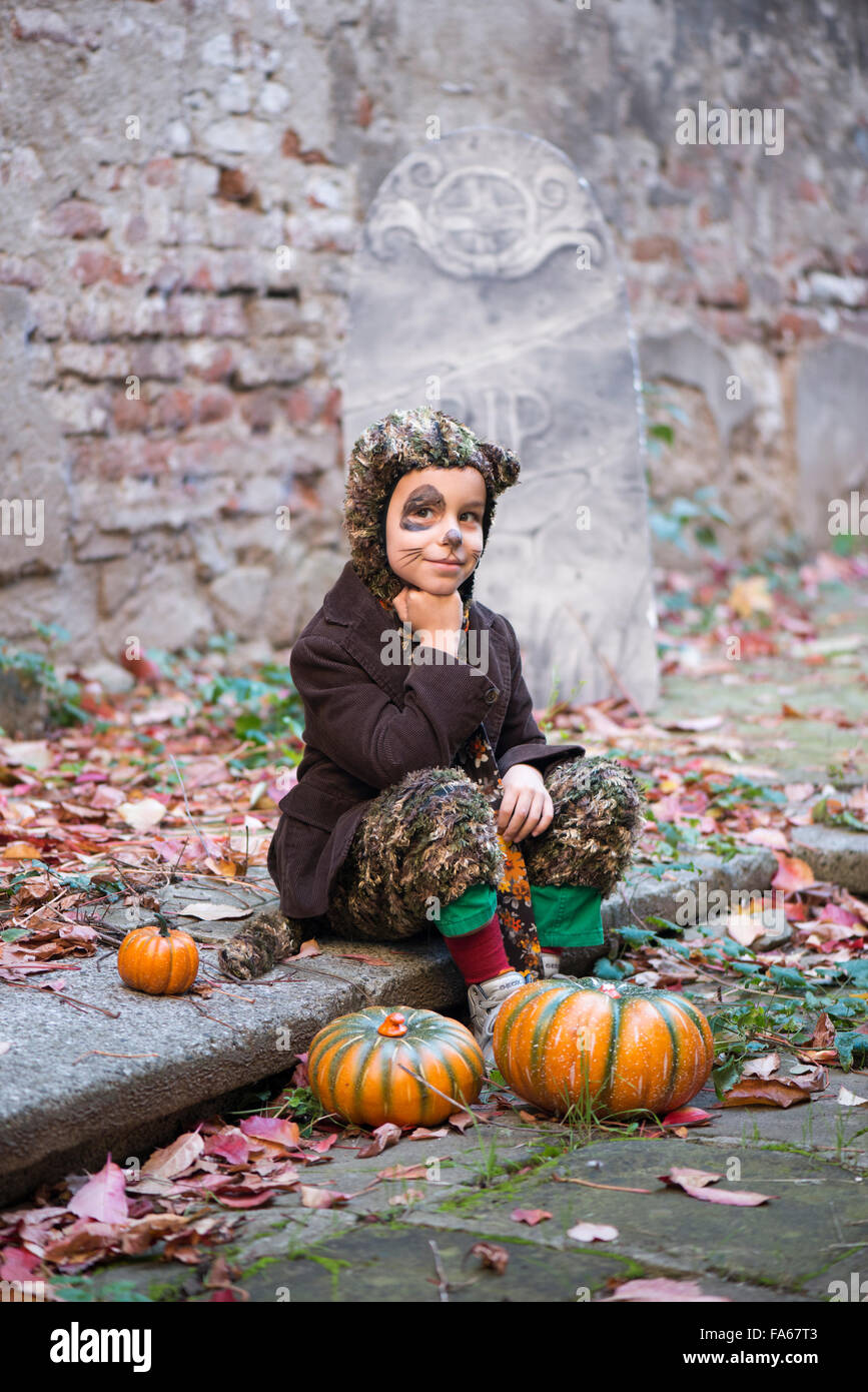 Ragazzo in costume di halloween seduto nel cimitero Foto Stock