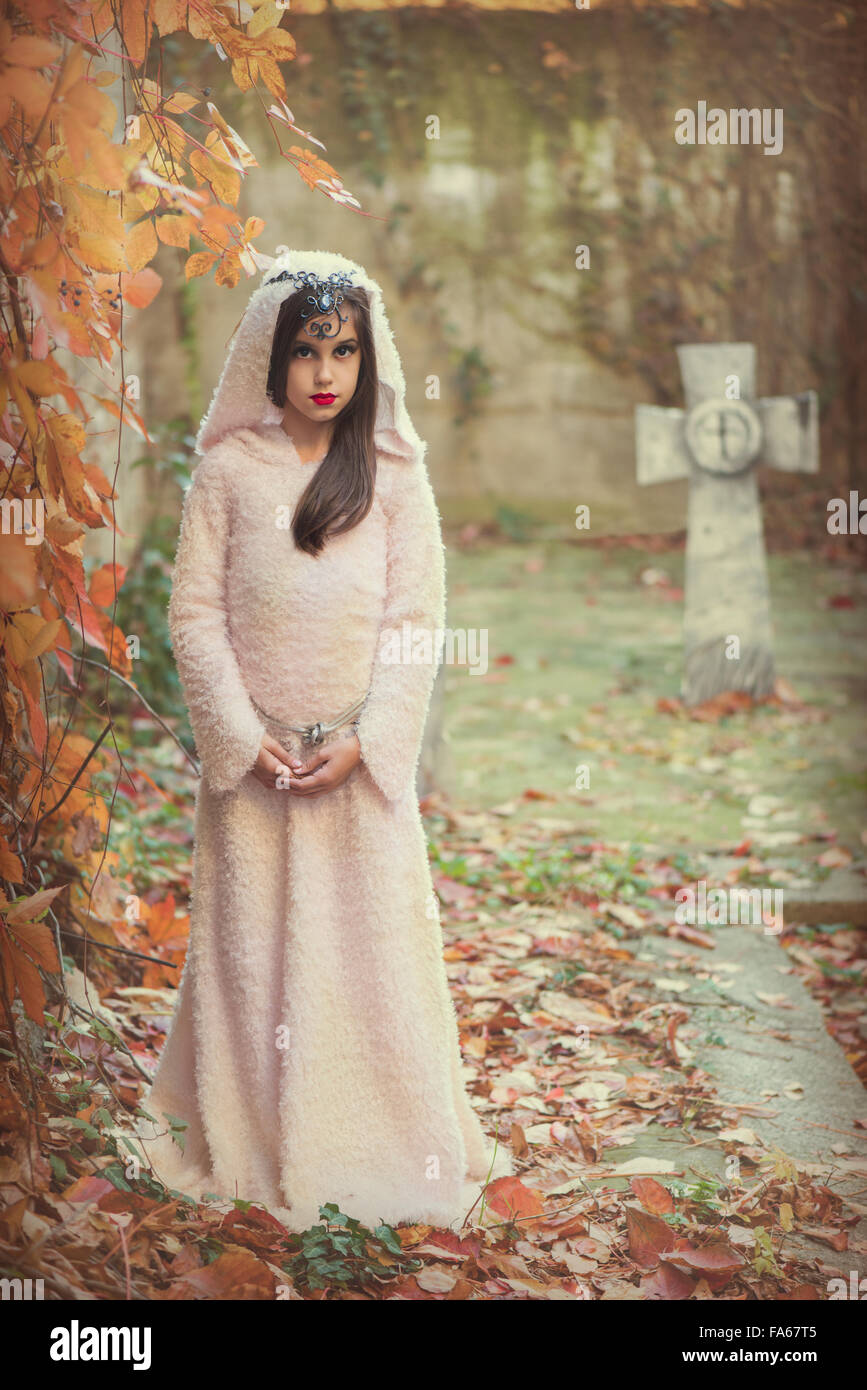 Ritratto di una ragazza in costume di halloween in piedi in un cimitero Foto Stock