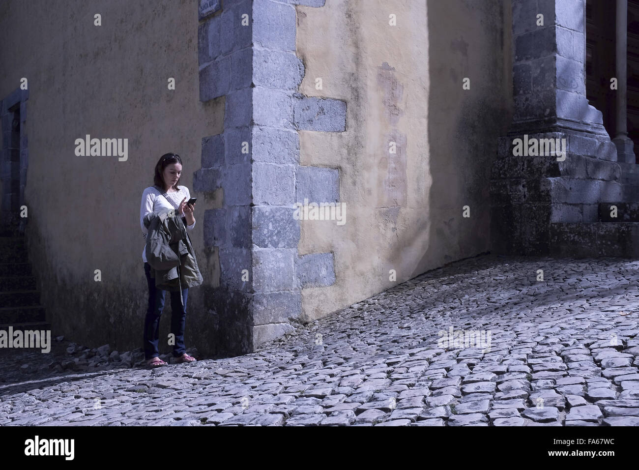 Donna in piedi in strada per la messaggistica di testo, Lisbona, Portogallo Foto Stock