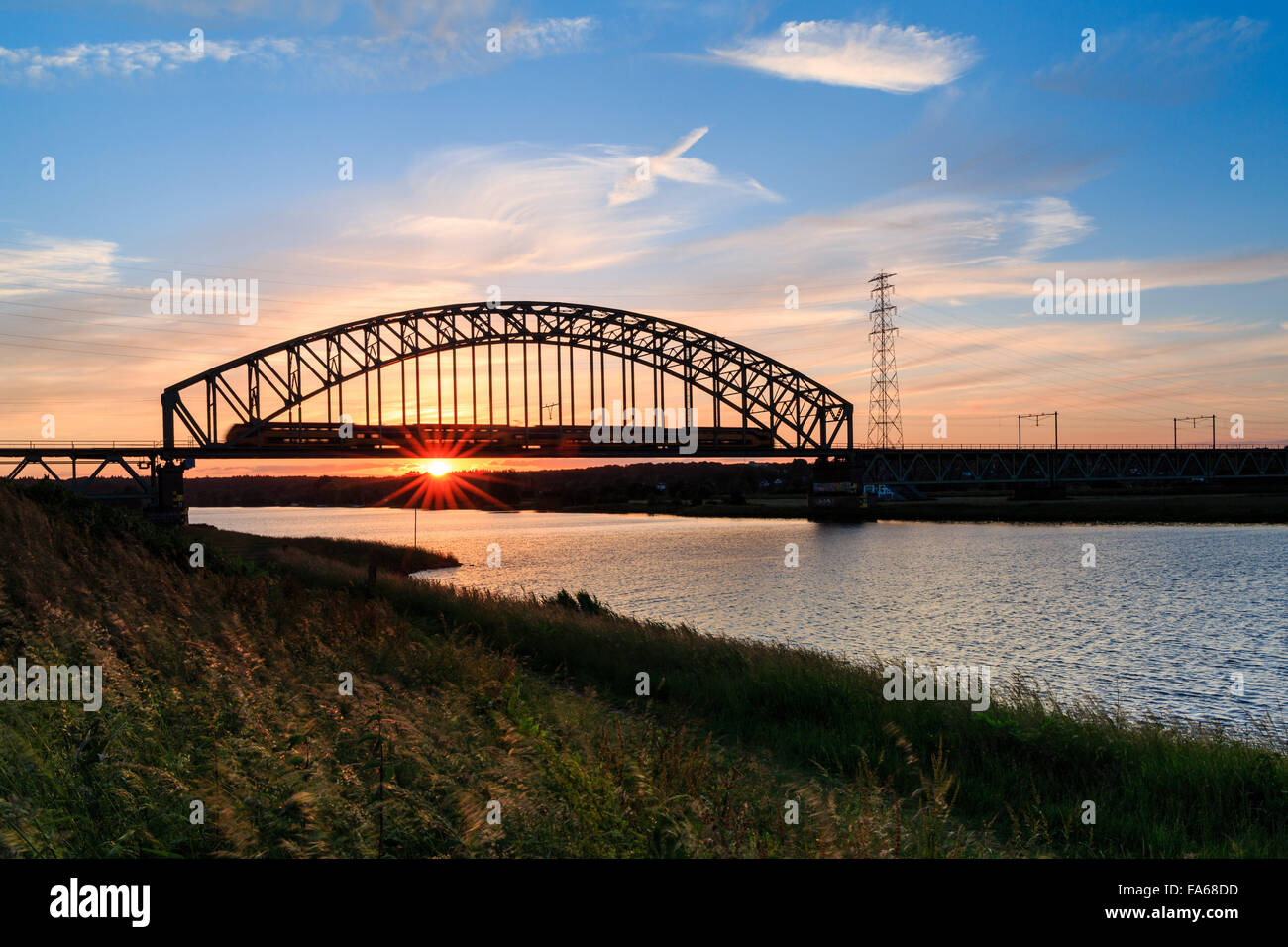 La guida dei treni attraverso ponte al tramonto di Arnhem, Gelderland, Nederland Foto Stock