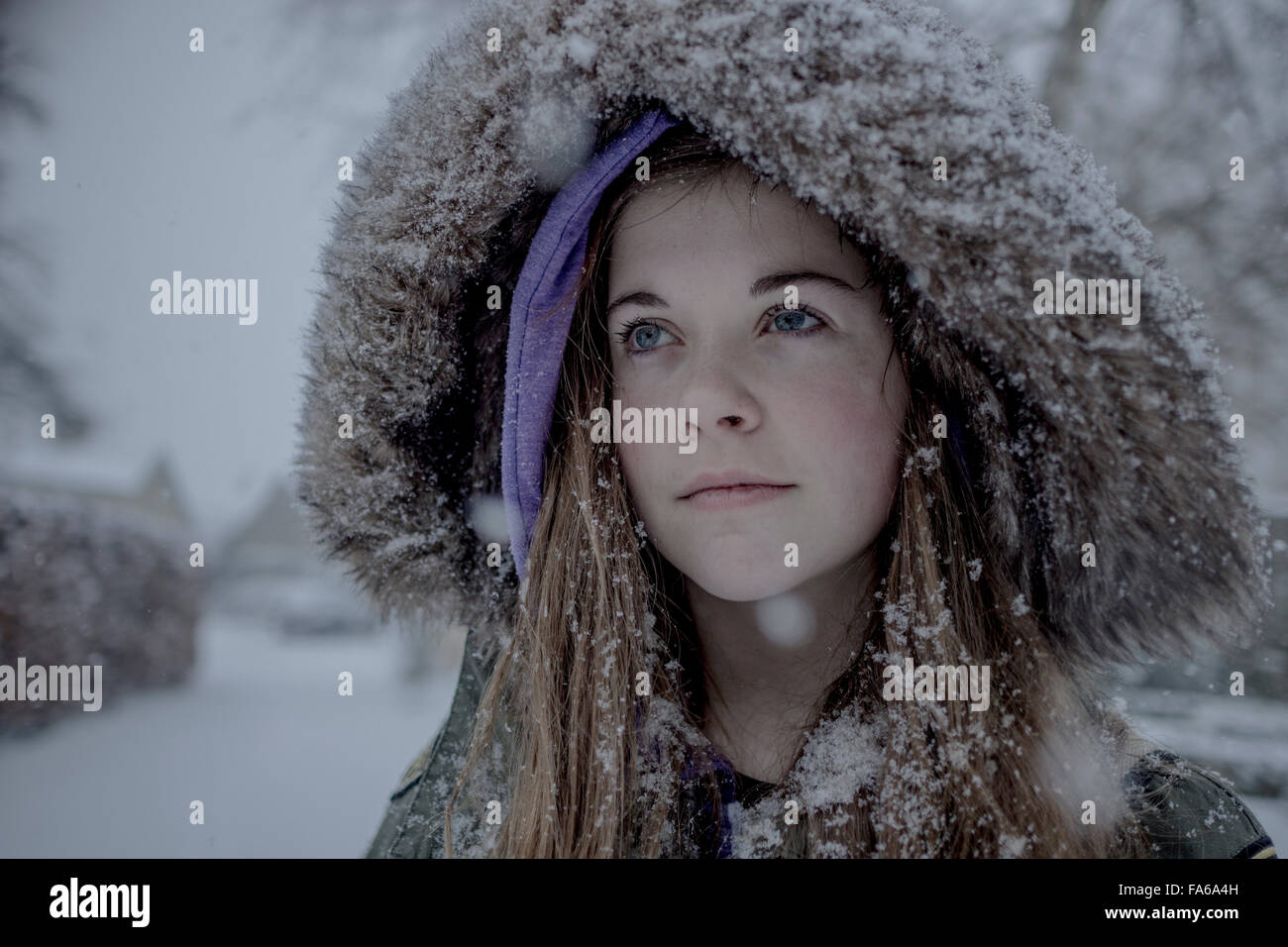 Ragazza adolescente che indossa una coperta di neve peloso giacca con cappuccio Foto Stock