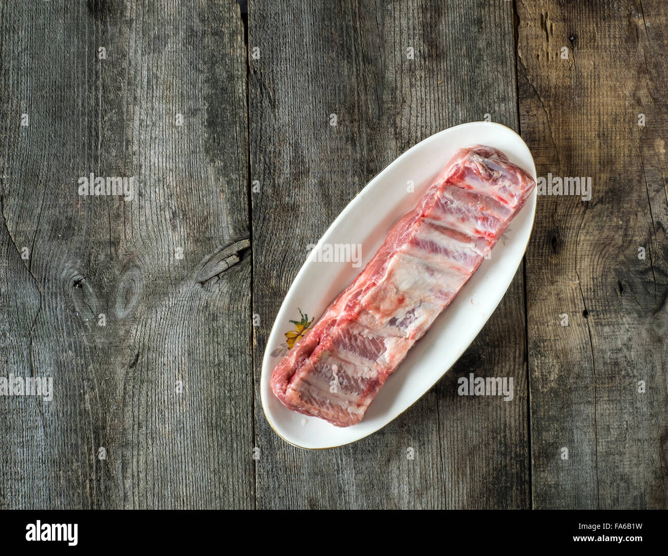 Materie costolette di maiale su una piastra su un tavolo di legno Foto Stock