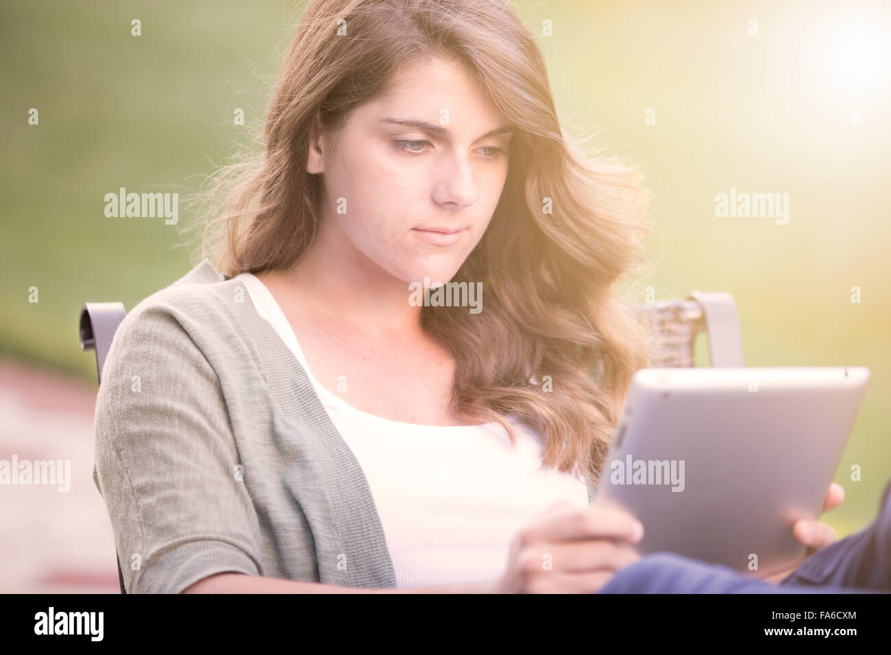 Ragazza adolescente di lettura su un tablet Foto Stock