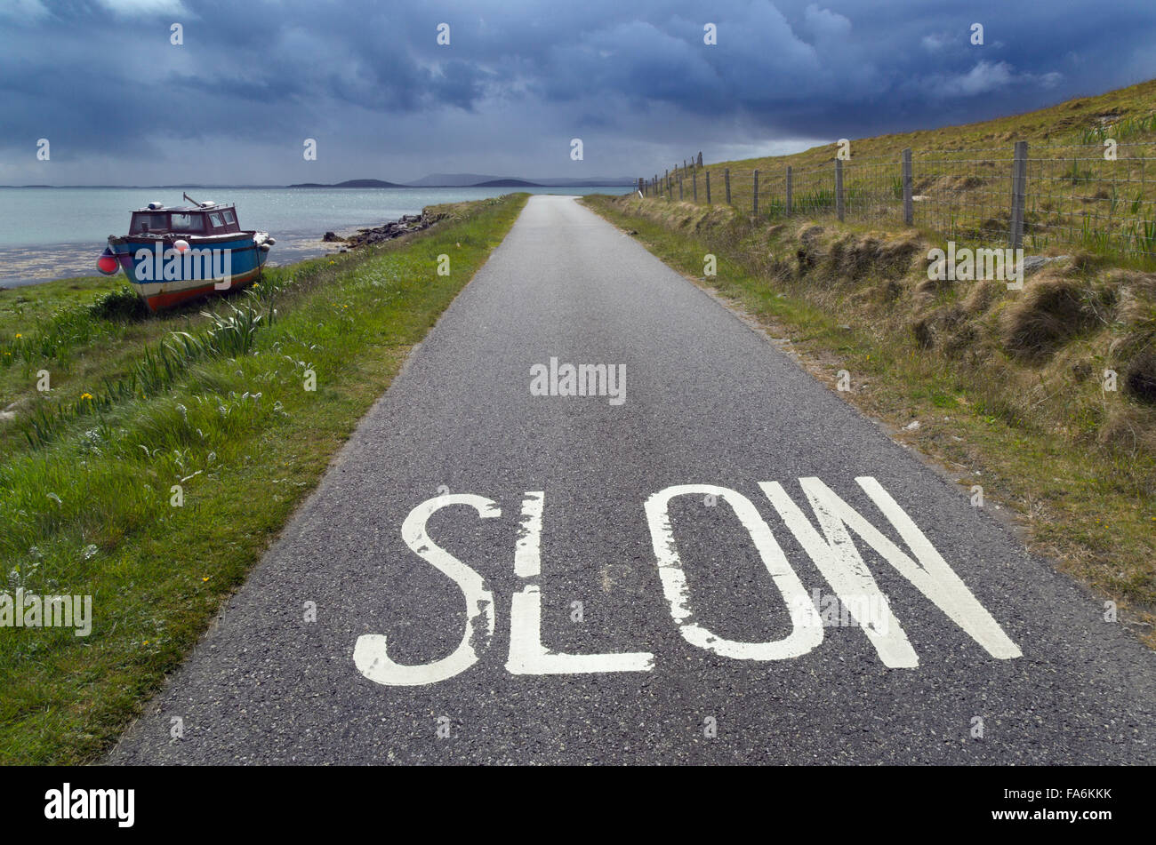 Unica via strada e vecchia barca a Baie Loch Berneray Ebridi Foto Stock