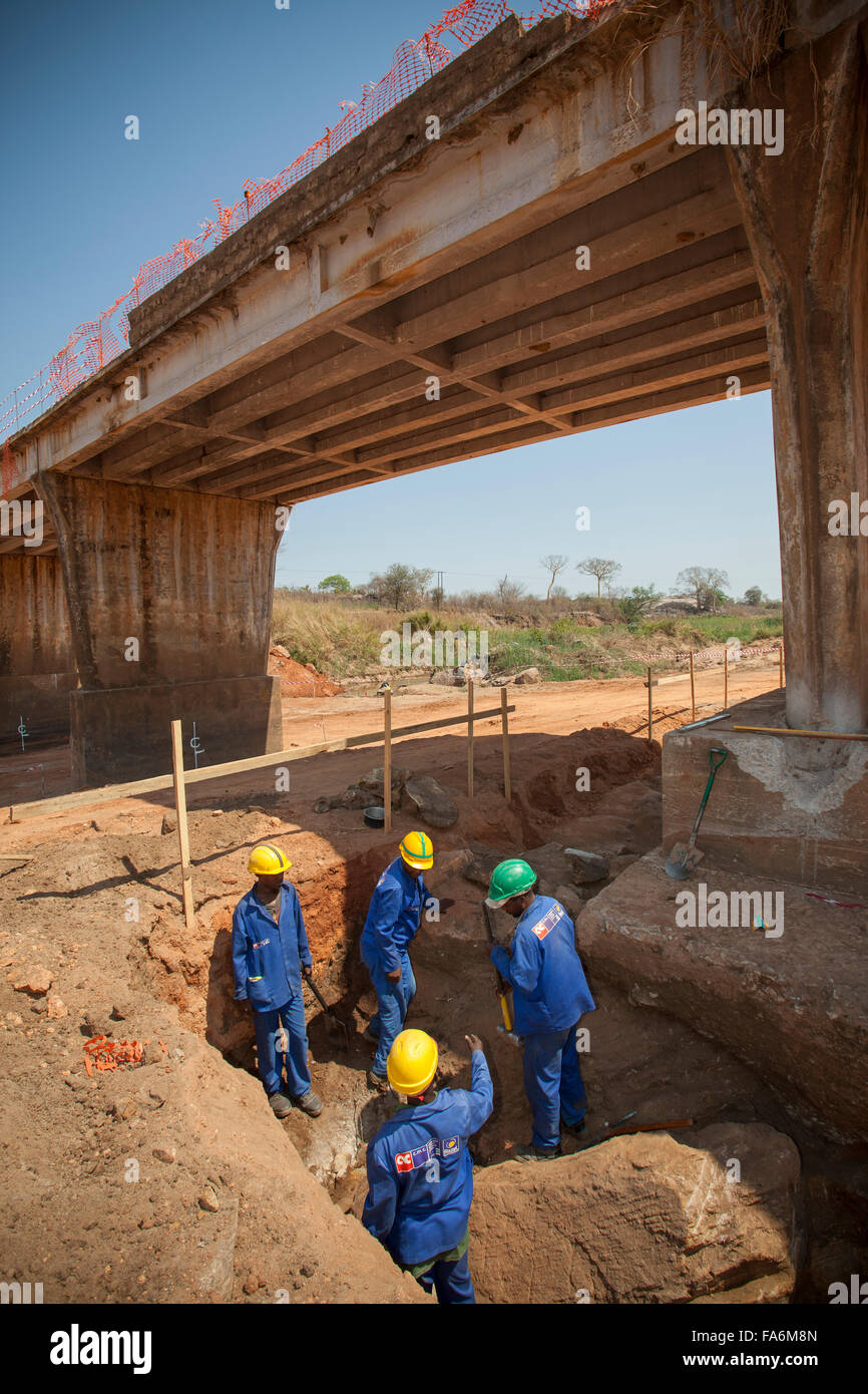 Lavoratori costruire un ponte lungo il Nampula a Rio Ligonha Road nel Mozambico settentrionale, se l'Africa. Foto Stock