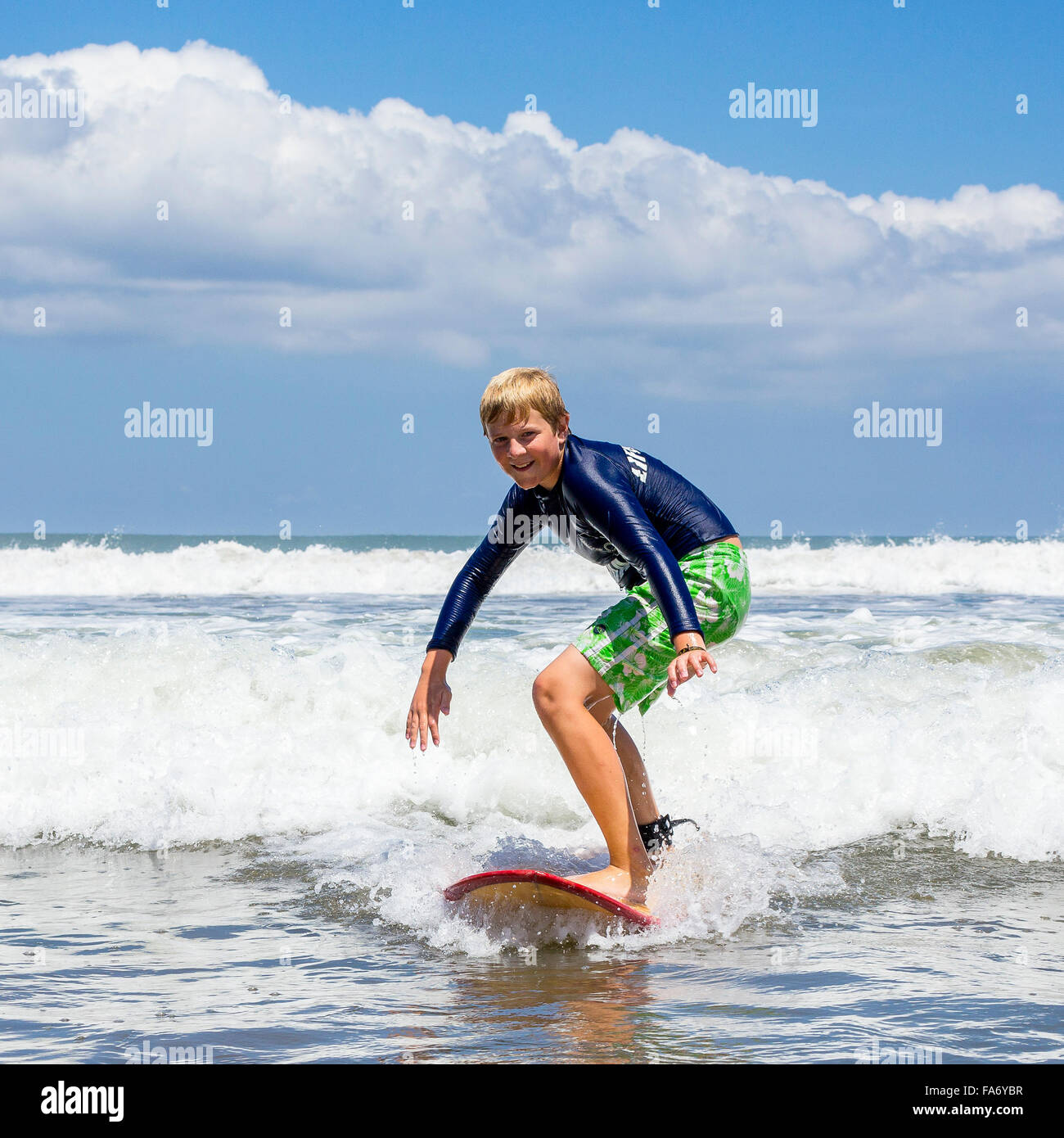 Un ragazzo, 12 anni, surf, Kuta, Legian beach e surf paradise, Bali, Indonesia Foto Stock