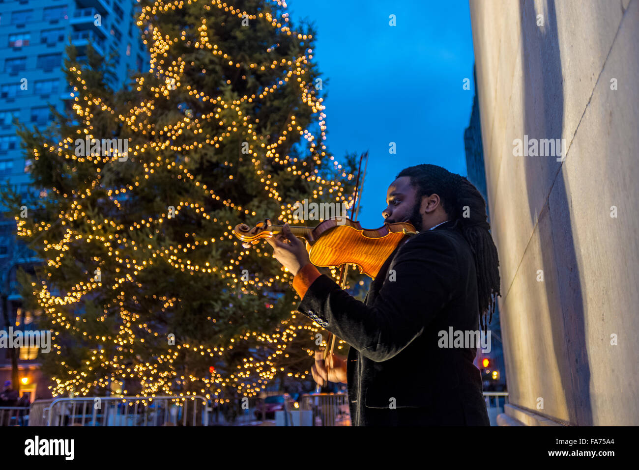 New York, NY 22 Dicembre 2015 - Il violinista la riproduzione di musica di Natale al di sotto dell'arco a Washington Square Park ©Stacy Rosenstock Walsh/Alamy Foto Stock