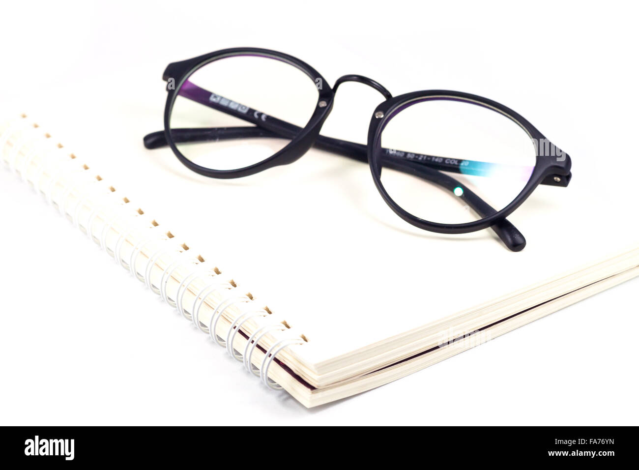 Vuoto notebook a spirale e occhiali isolati su sfondo bianco, stock photo Foto Stock