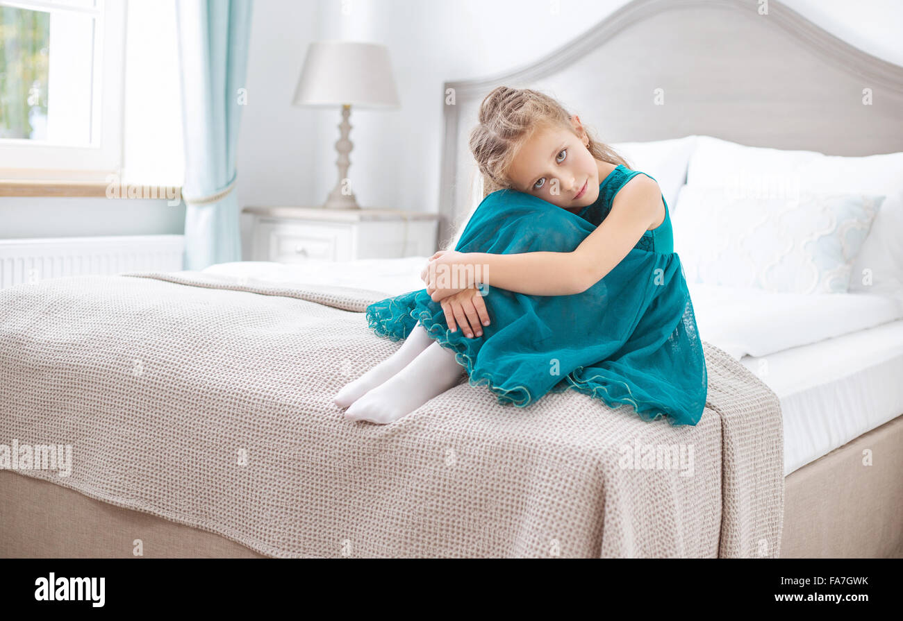 Triste giovane ragazza seduta in camera da letto Foto Stock