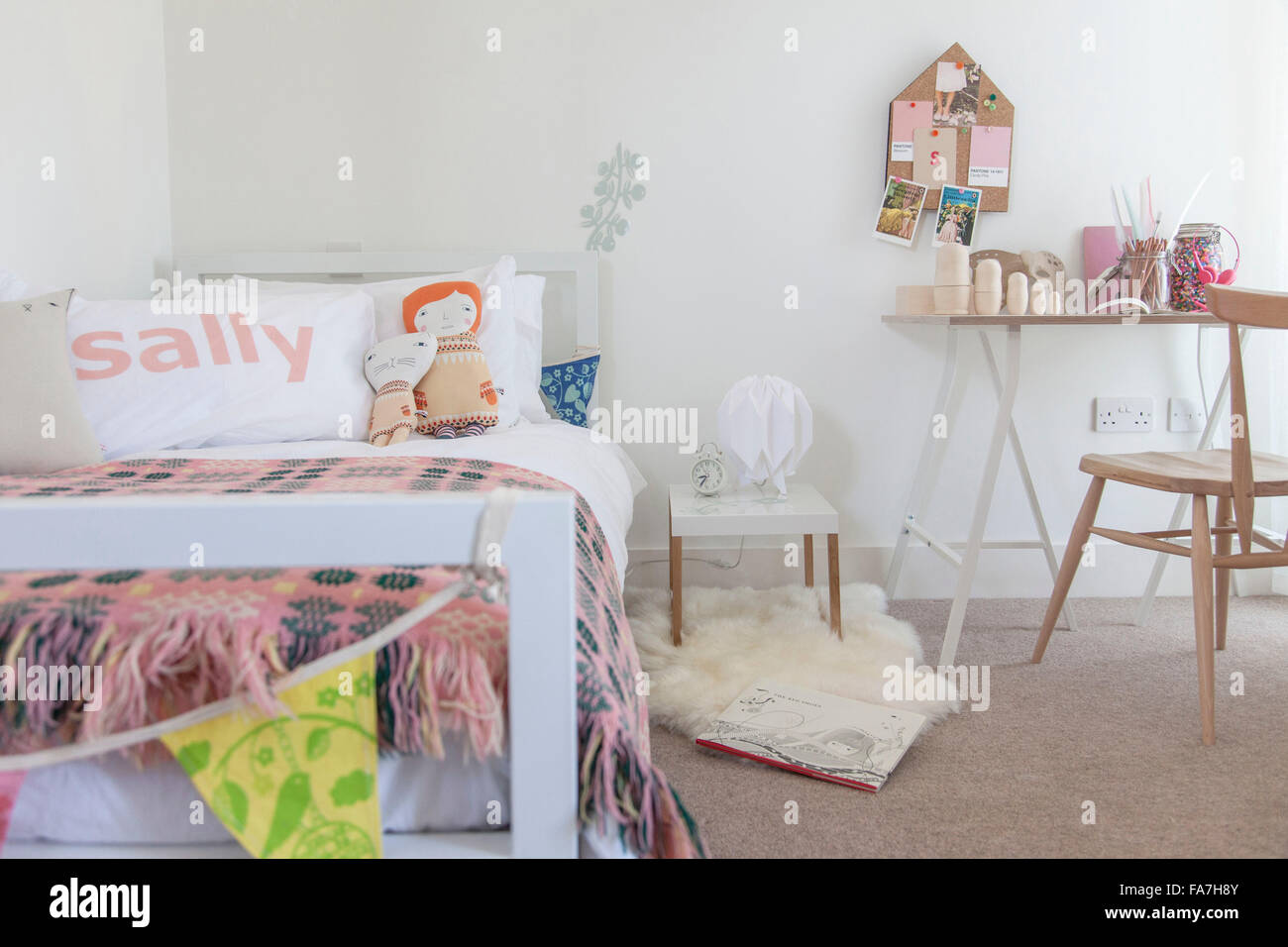 Letto singolo camera da letto delle ragazze. Una casa combinando stile moderno minimalista con la visualizzazione di oggetti tradizionali utilizzate nella vita di ogni giorno. Foto Stock