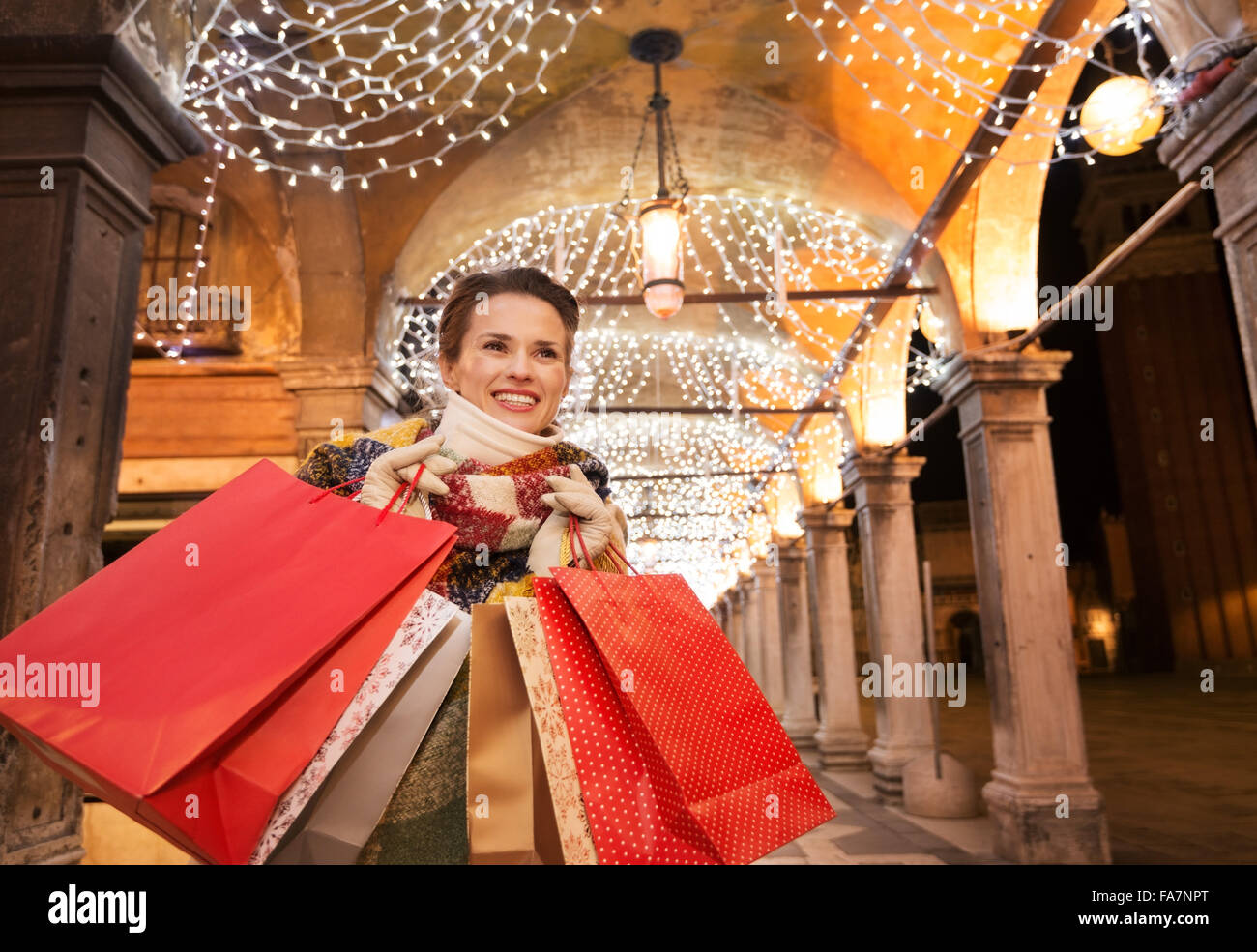 È tempo di moda per lo shopping in avanti per una più auspicabile di regali di Natale a Venezia, Italia. Donna felice con le borse della spesa lo Foto Stock